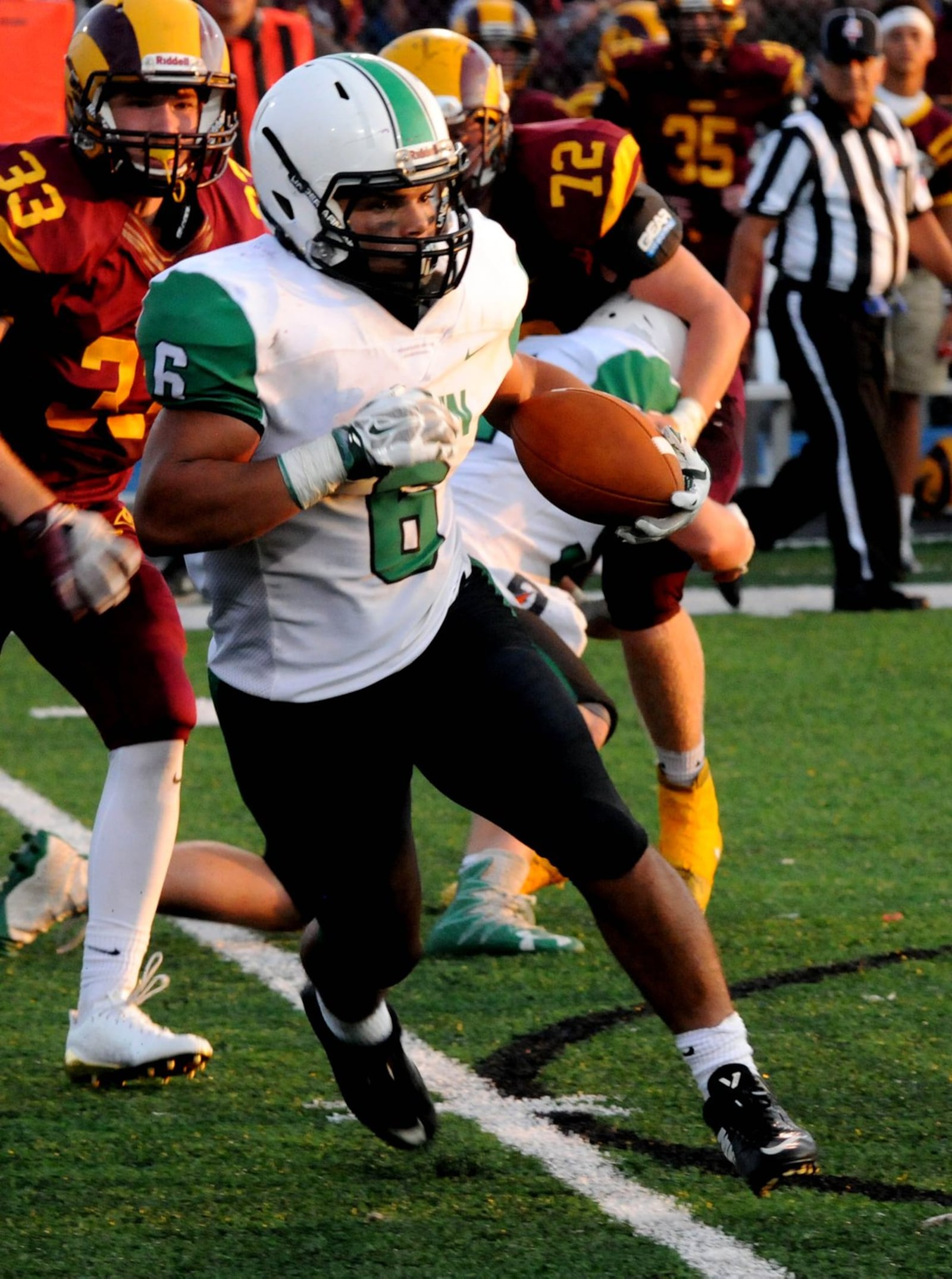 Badin’s Lavassa Martin gets past Ross defenders Anthony Records (33) and Logan Lange (72) during a 36-6 triumph in the Skyline Chili Crosstown Showdown at Hamilton’s Virgil Schwarm Stadium. CONTRIBUTED PHOTO BY DAVID A. MOODIE