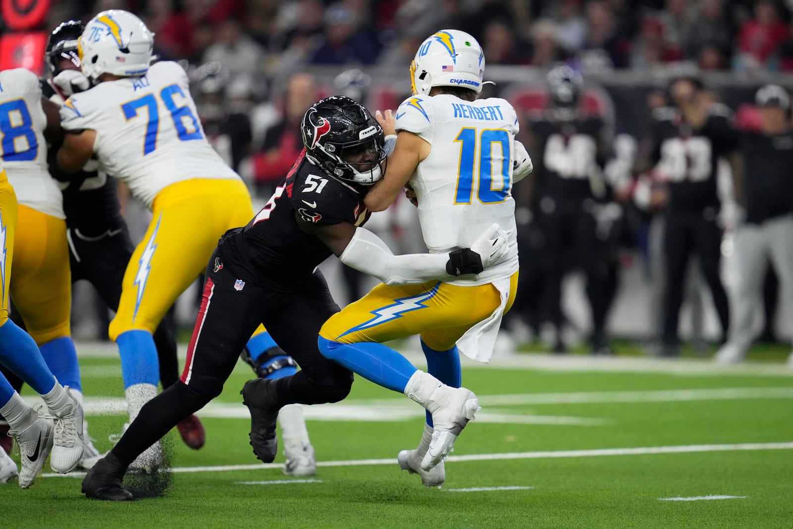 Los Angeles Chargers quarterback Justin Herbert (10) is sacked by Houston Texans' Will Anderson Jr. (51) during the second half of an NFL wild-card playoff football game Saturday, Jan. 11, 2025, in Houston. (AP Photo/Ashely Landis)