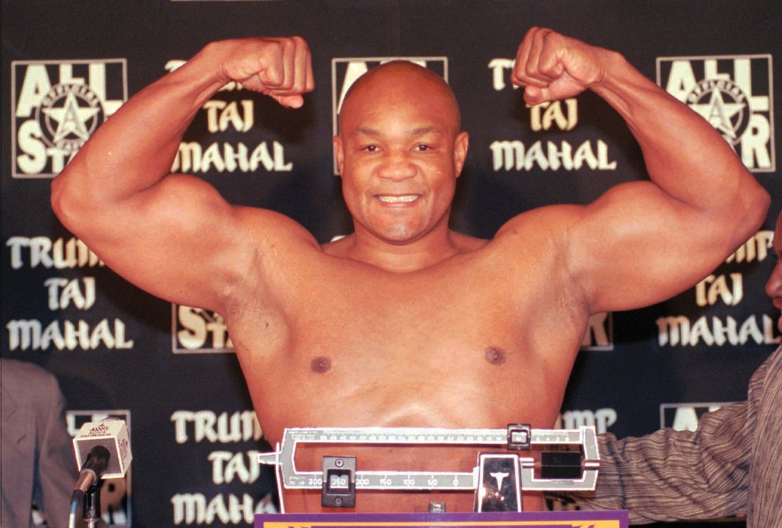 FILE - Heavyweight boxer George Foreman flexes his muscles after weighing in at 260 pounds for his upcoming fight against Shannon Briggs at the Trump Taj Mahal Casino Resort in Atlantic City., N.J., Thursday, Nov. 20, 1997. ((AP Photo/Charles Rex Arbogast, File)