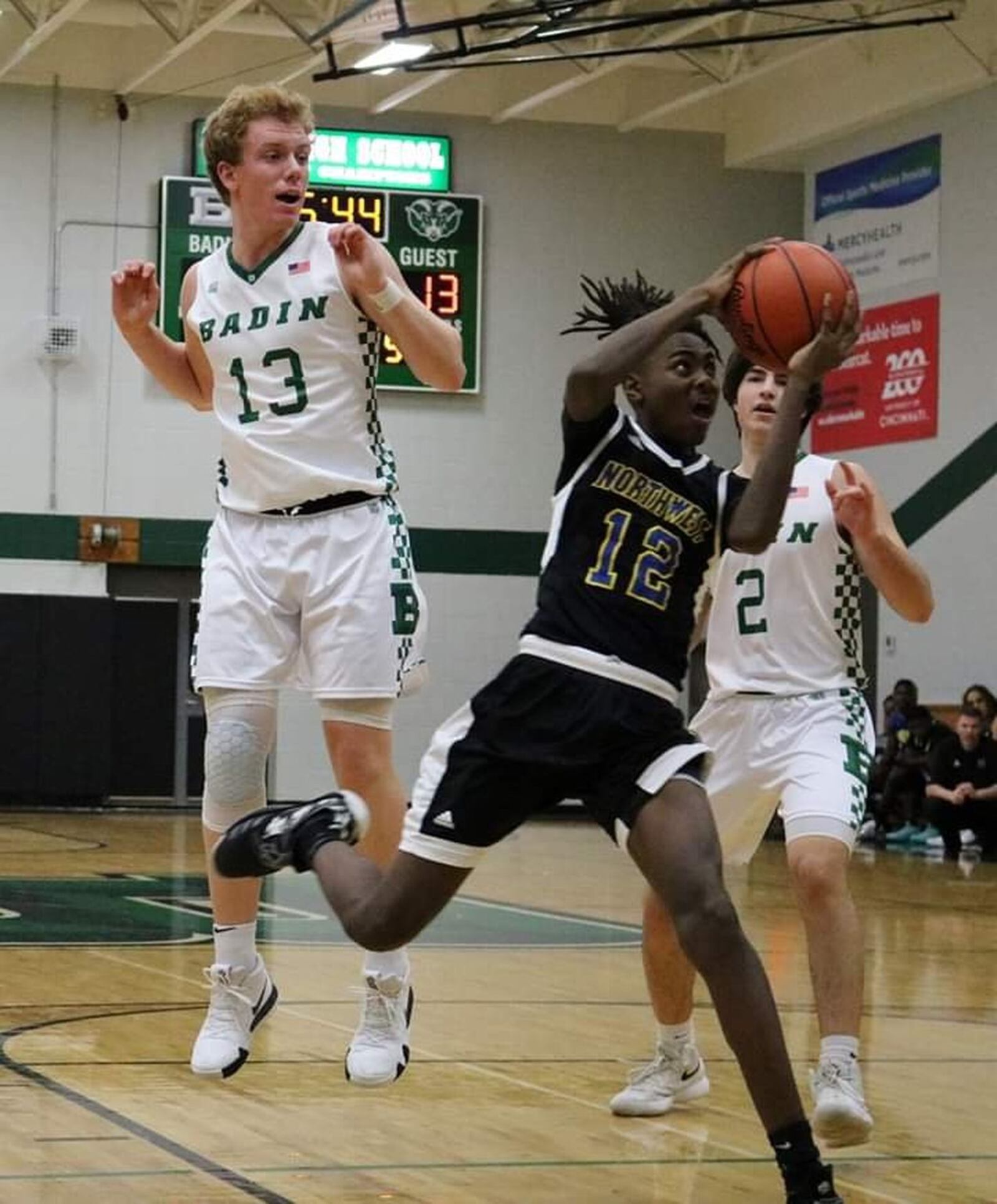 Northwest’s Evan Mahaffey (12) gets past Badin’s Justin Pappas (13) and Seth Hargis (2) during Tuesday night’s game at Mulcahey Gym in Hamilton. Badin won 70-52. CONTRIBUTED PHOTO BY TERRI ADAMS