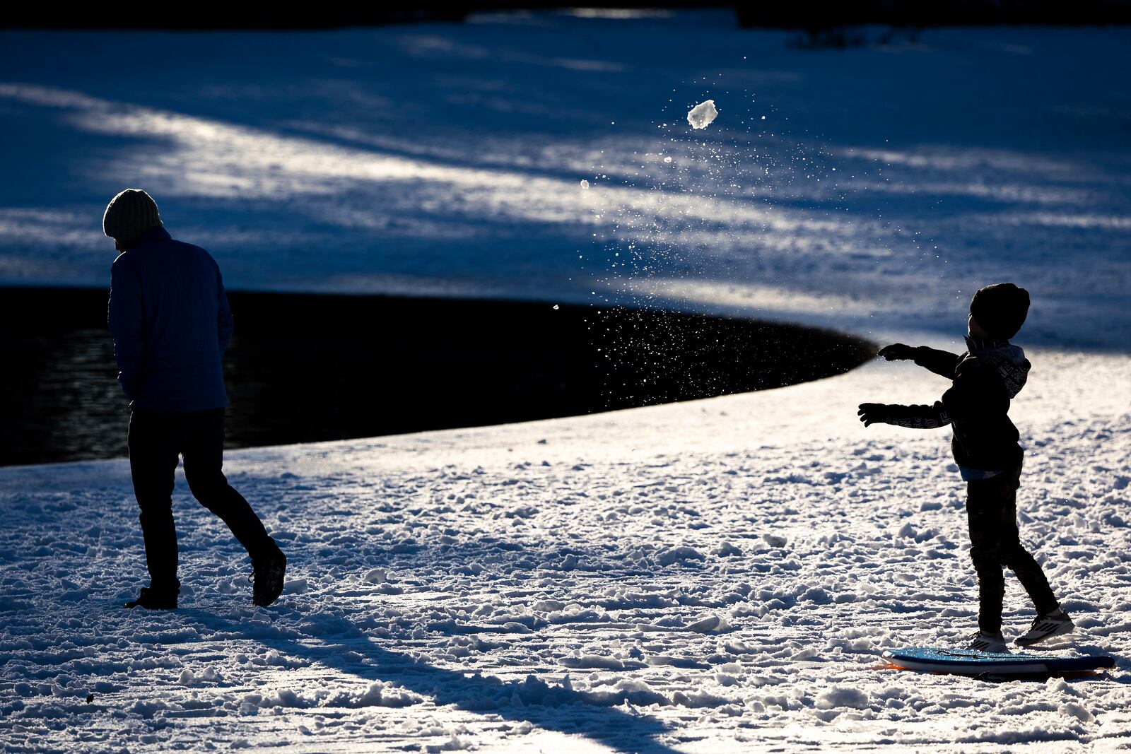 A child throws a snowball at his father in Hampton Park after a winter storm dropped ice and snow Wednesday, Jan. 22, 2025, in Charleston, S.C. (AP Photo/Mic Smith)