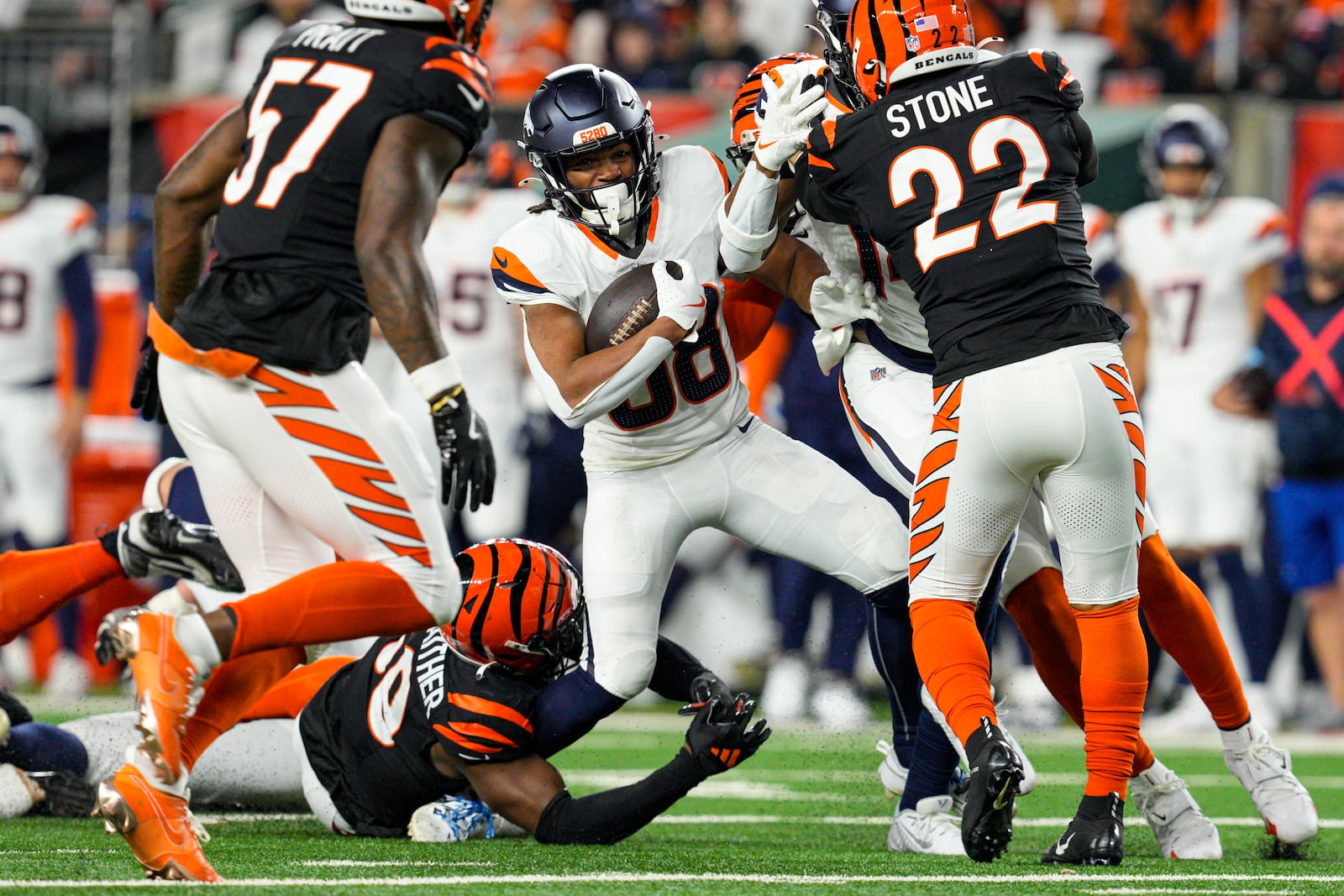 Denver Broncos running back Jaleel McLaughlin (38) is tackled by Cincinnati Bengals linebacker Akeem Davis-Gaither (59) during the second half of an NFL football game in Cincinnati, Saturday, Dec. 28, 2024. (AP Photo/Jeff Dean)