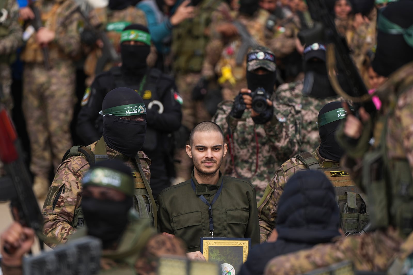 Israeli hostage Omer Wenkert, centre, is escorted by Hamas fighters before being handed over to the Red Cross in Nuseirat, central Gaza Strip, Saturday, Feb. 22, 2025. (AP Photo/Abdel Kareem Hana)