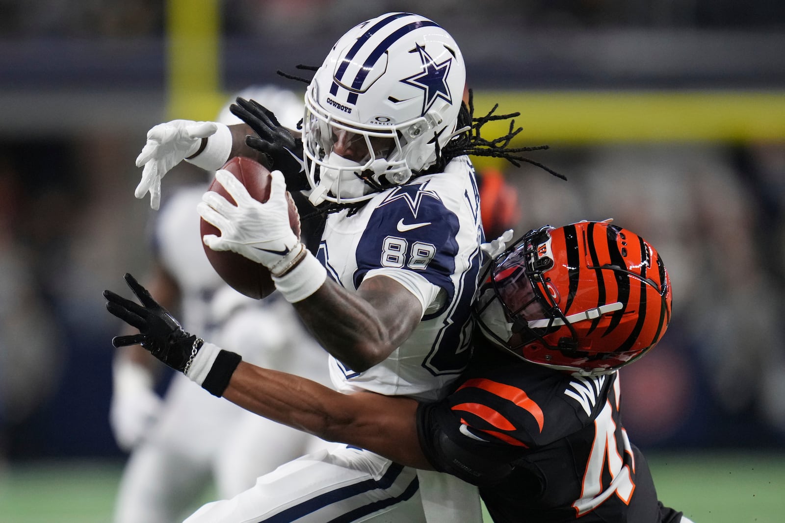 Dallas Cowboys wide receiver CeeDee Lamb (88) catches the ball as Cincinnati Bengals cornerback Marco Wilson (42) defends during the first half of an NFL football game, Monday, Dec. 9, 2024, in Arlington, Texas. (AP Photo/Julio Cortez)