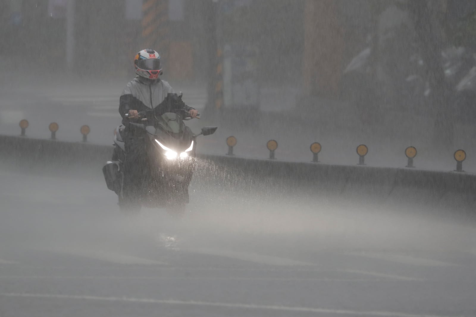 A man rides motorbike as Typhoon Kong-rey approaches in Taipei, Taiwan, Thursday, Oct. 31, 2024. (AP Photo/Chiang Ying-ying)