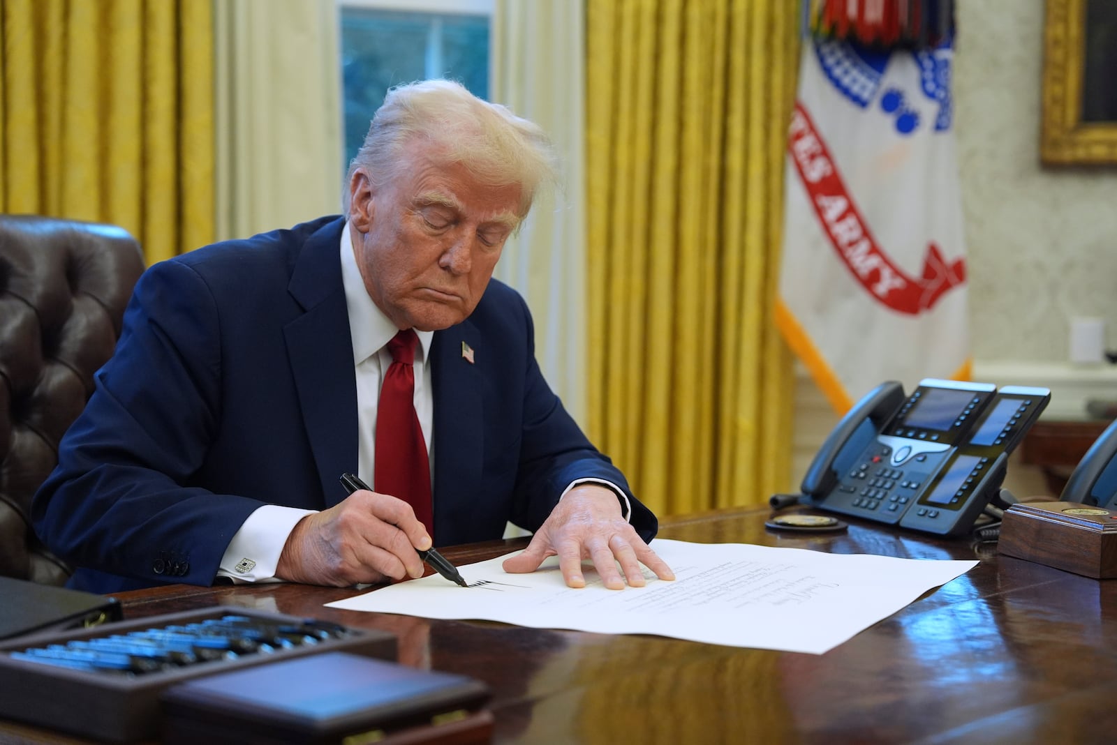 FILE - President Donald Trump signs a document in the Oval Office at the White House, Jan. 30, 2025, in Washington. (AP Photo/Evan Vucci, File)