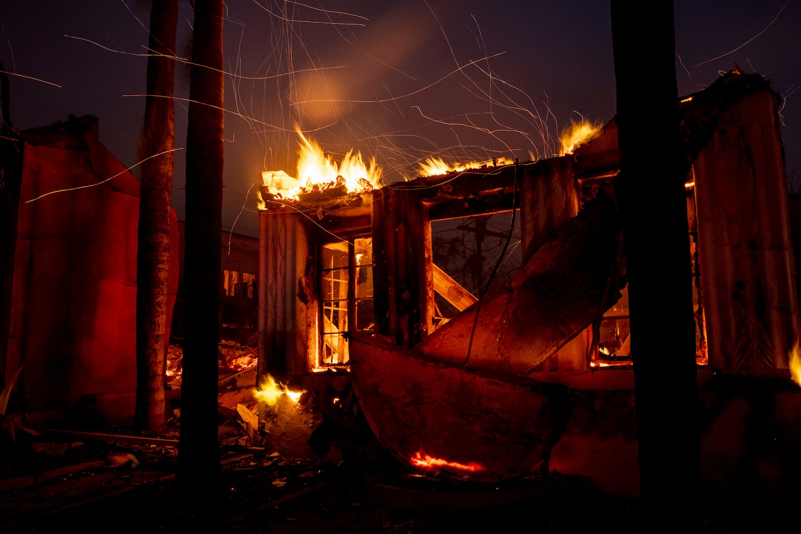 Embers fly from a burning structure during the Eaton fire in Altadena, Calif., Wednesday, Jan. 8, 2025. (Stephen Lam/San Francisco Chronicle via AP)