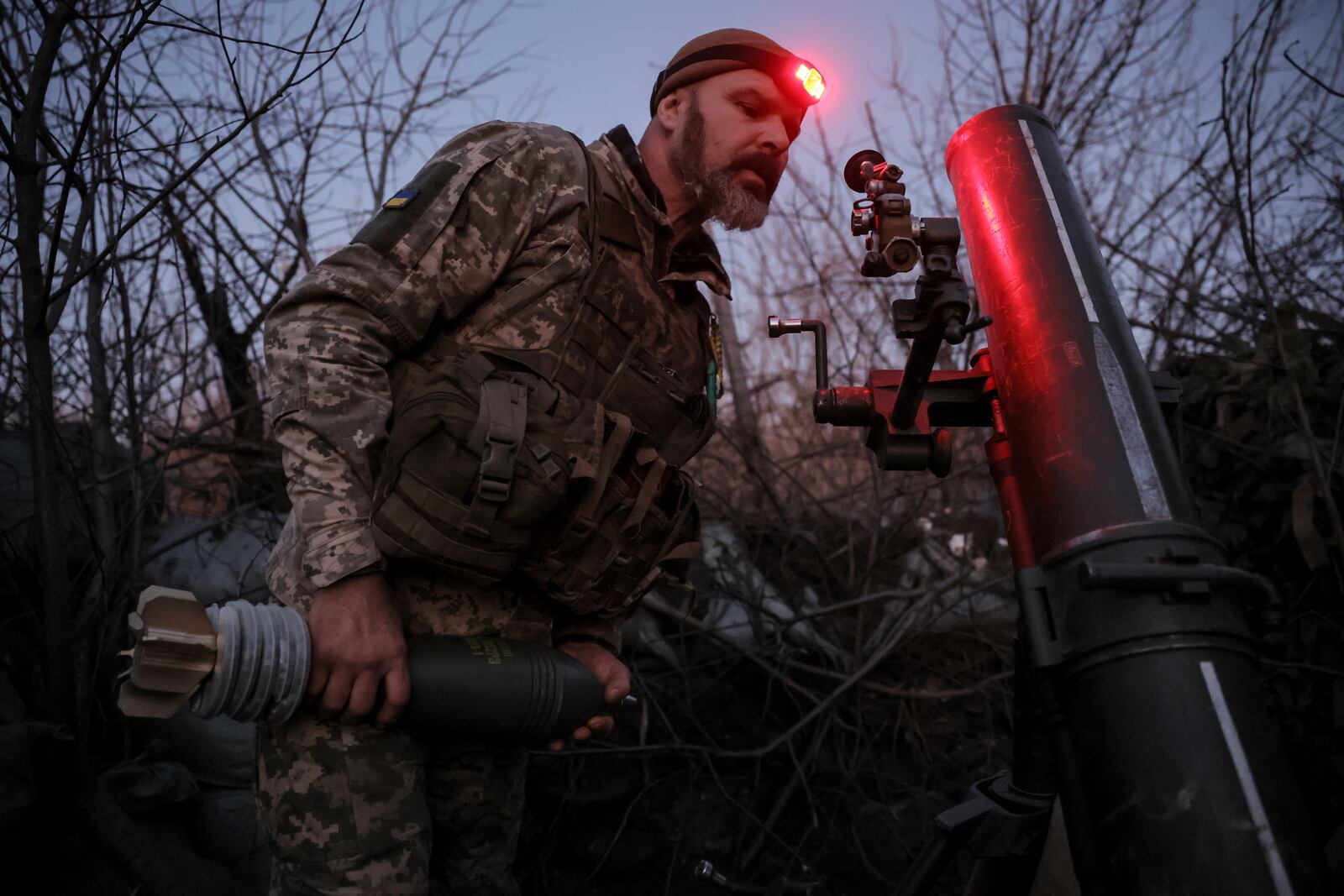 In this photo provided by Ukraine's 24th Mechanised Brigade press service, serviceman of the 24th Mechanised Brigade prepares to fire 120mm mortar towards Russian positions near Chasiv Yar town, in Donetsk region, Ukraine, Tuesday, Nov. 19, 2024. (Oleg Petrasiuk/Ukrainian 24th Mechanised Brigade via AP)