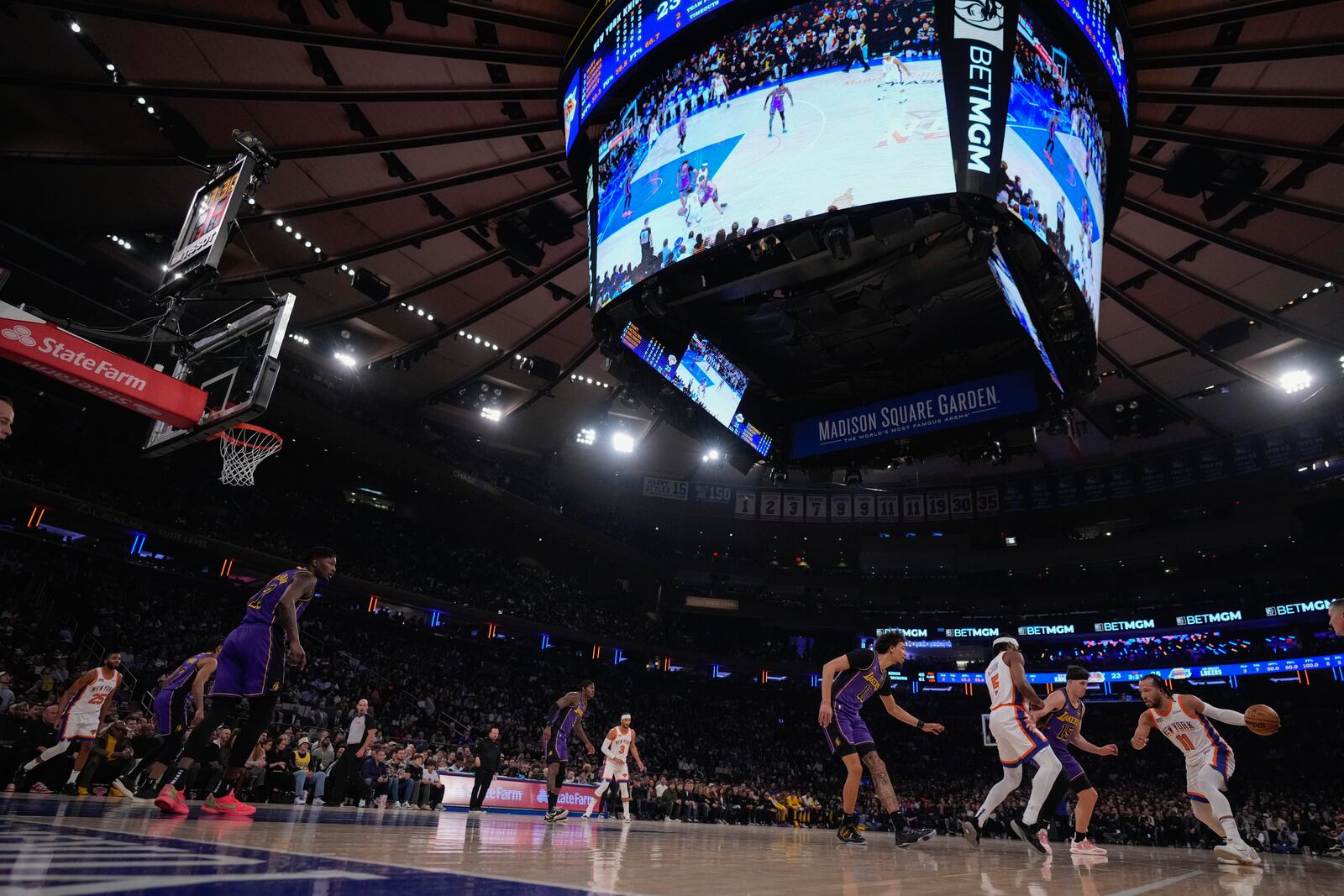 New York Knicks' Jalen Brunson (11) drives past Los Angeles Lakers' Austin Reaves (15) during the first half of an NBA basketball game Saturday, Feb. 1, 2025, in New York. (AP Photo/Frank Franklin II)