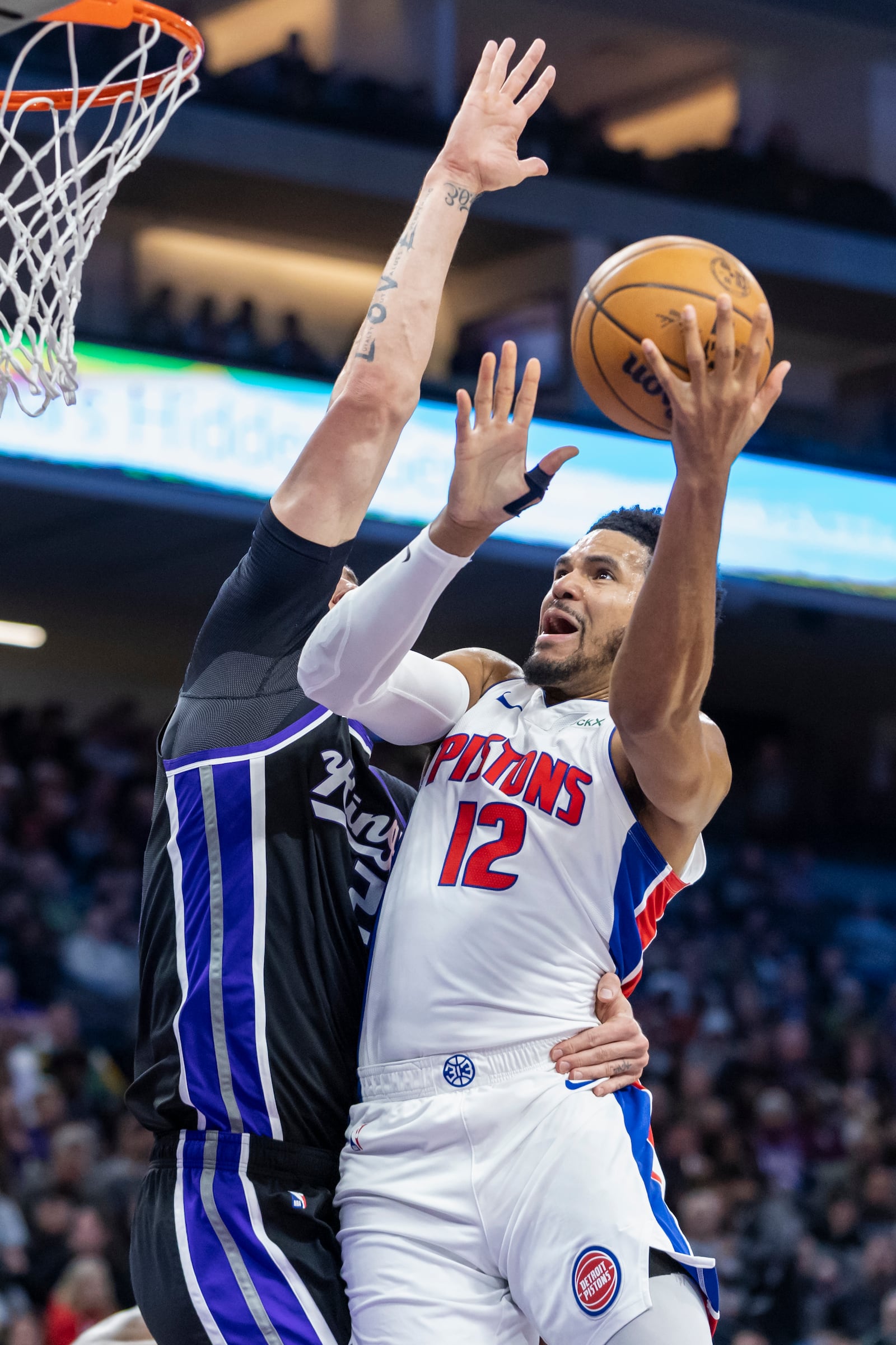 Detroit Pistons forward Tobias Harris (12) attempts a layup over Sacramento Kings center Alex Len, left, during the first half of an NBA basketball game Thursday, Dec. 26, 2024, in Sacramento, Calif. (AP Photo/Sara Nevis)