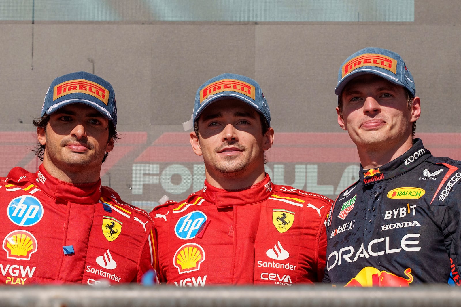 Ferrari drivers Carlos Sainz, from left, of Spain, who finished in second stands by race winner and teammate Charles Leclerc, of Monaco, and Red Bull driver Max Verstappen, of the Netherlands, who placed third in the U.S. Grand Prix auto race at Circuit of the Americas, Sunday, Oct. 20, 2024, in Austin, Texas. (AP Photo/Nick Didlick)