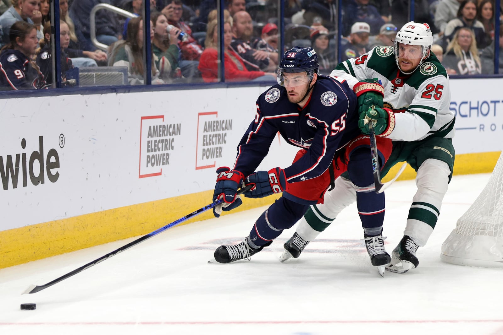 Columbus Blue Jackets defenseman David Jiricek, left, reaches for the puck in front of Minnesota Wild defenseman Jonas Brodin during the second period of an NHL hockey game in Columbus, Ohio, Saturday, Oct. 19, 2024. (AP Photo/Paul Vernon)