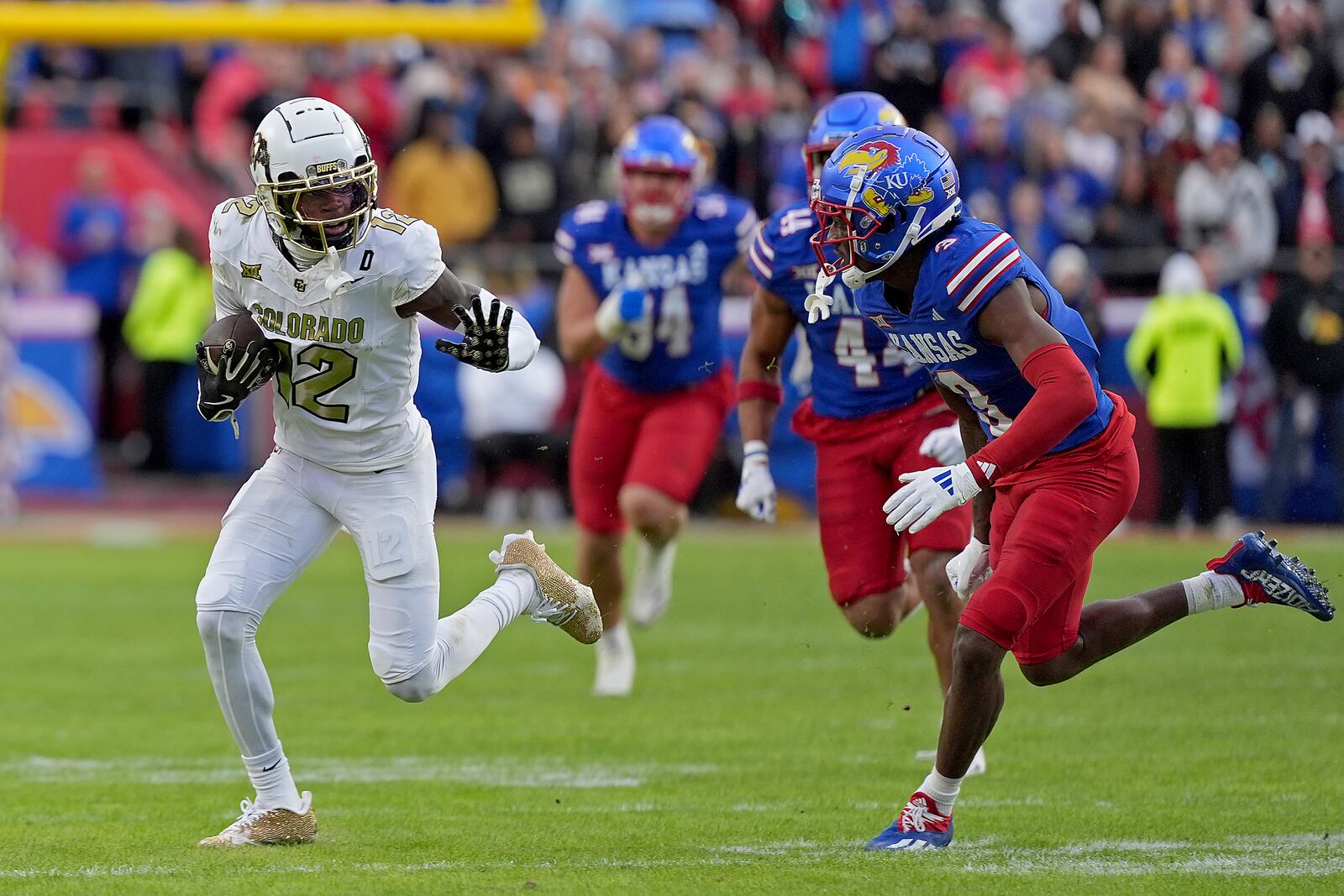 Colorado wide receiver Travis Hunter (12) runs for a first down during the first half of an NCAA college football game against Kansas, Saturday, Nov. 23, 2024, in Kansas City, Mo. (AP Photo/Charlie Riedel)