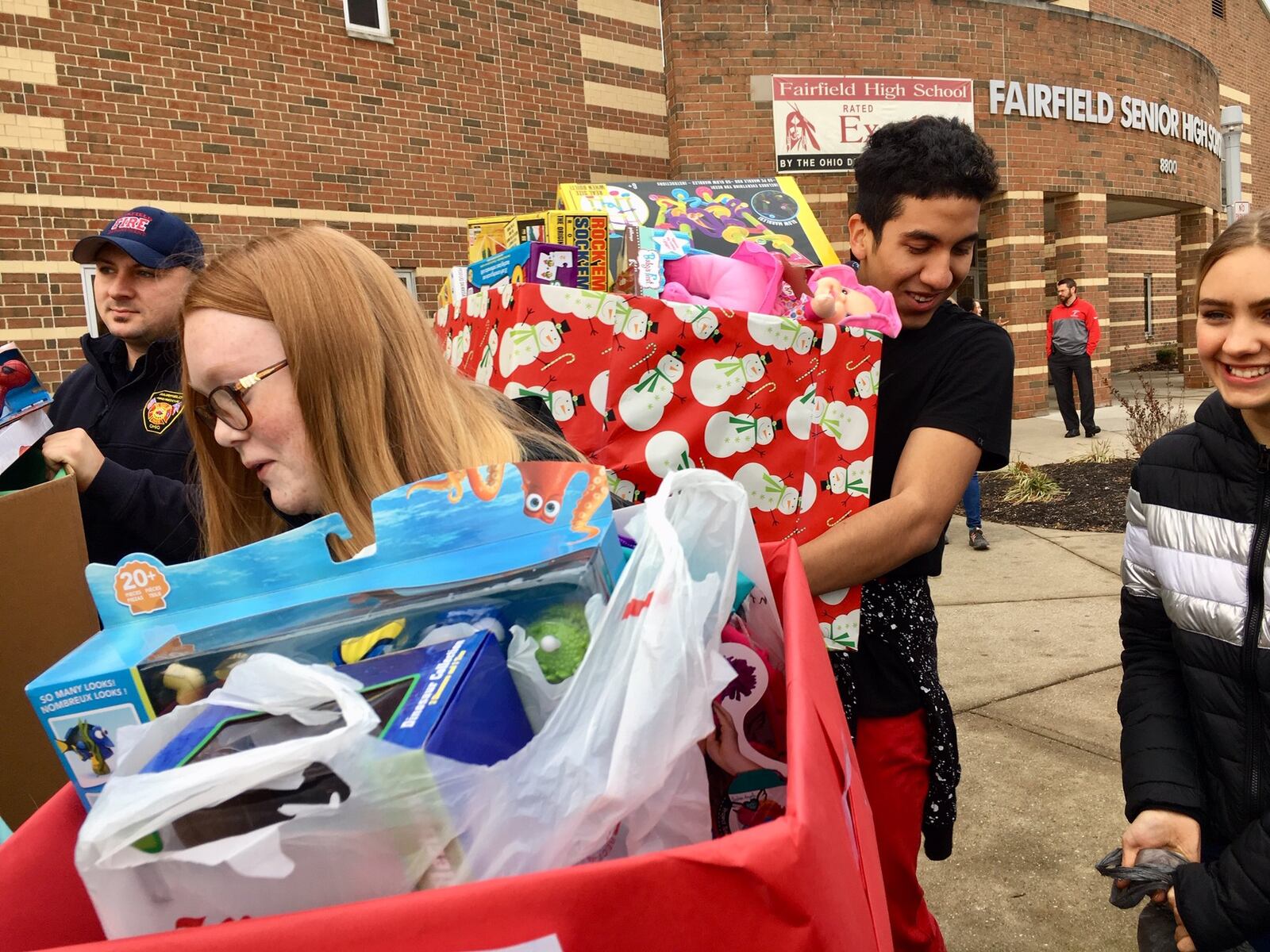 Students from Fairfield High School carry boxes of donated Christmas toys they sorted earlier for area foster children into a giant truck outside the Butler County school. The volunteering students are part of Students Against Distracted Driving and they are helping spread holiday cheer for foster kids through the county’s Children’s Services Agency. The annual gift drive collected 1,496 gifts this year.