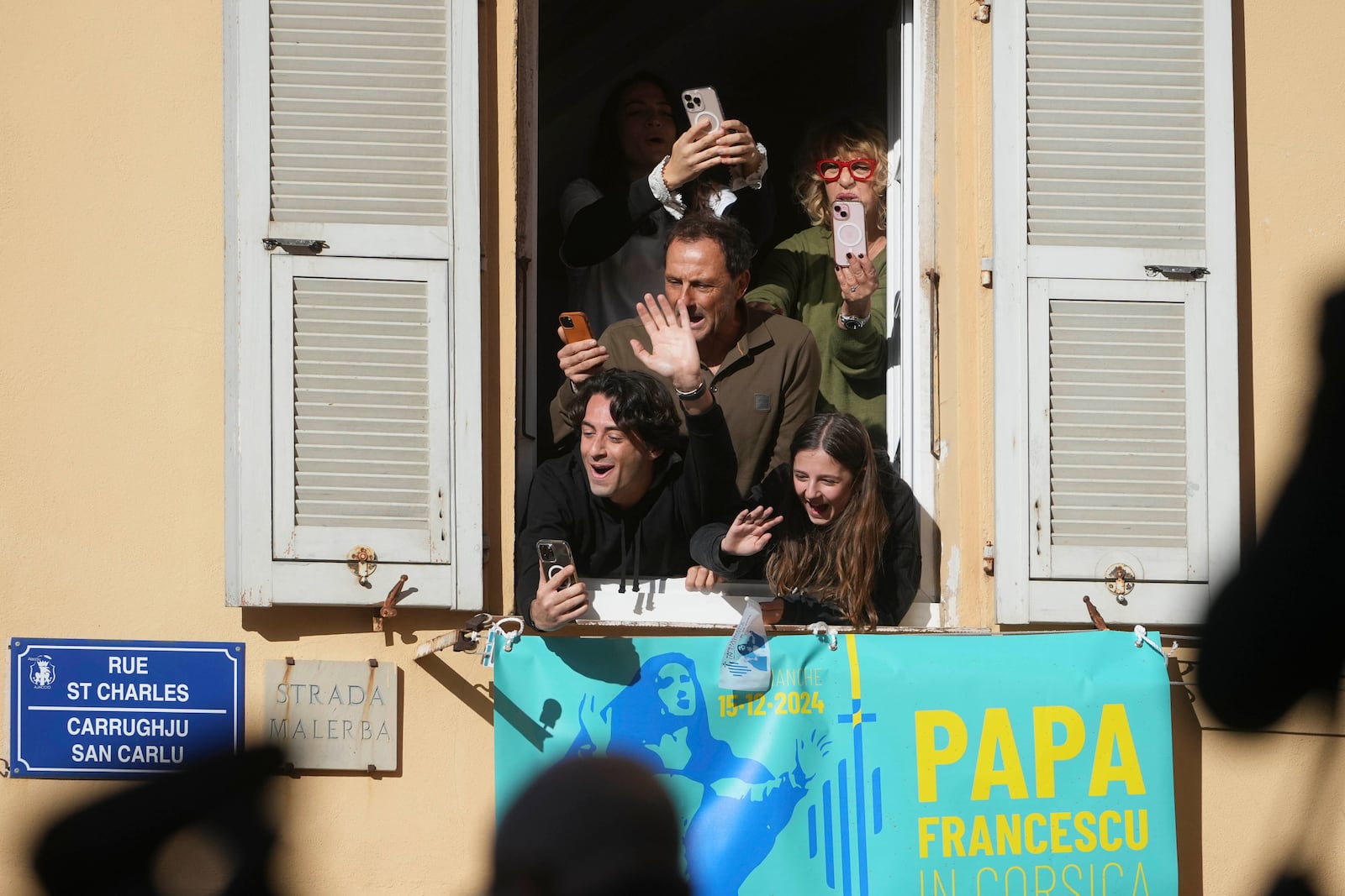 Faithful greet Pope Francis arriving outside the Cathedral of Our Lady of the Assumption of Ajaccio on the occasion of his one-day visit in the French island of Corsica, Sunday, Dec. 15, 2024. (AP Photo/Alessandra Tarantino)