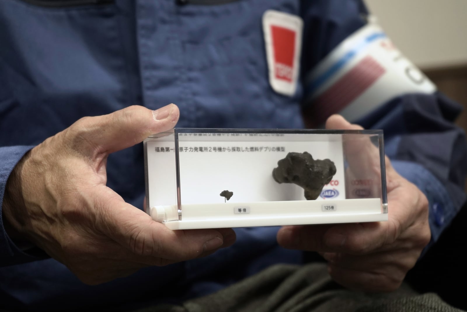 Akira Ono, chief decommissioning officer at the Tokyo Electric Power Company Holdings(TEPCO), holds model of nuclear fuel debris which was extracted from the damaged Fukushima Daiichi nuclear power plant last year, during an interview with the Associated Press Wednesday, March 5, 2025, in Tokyo. (AP Photo/Mayuko Ono)