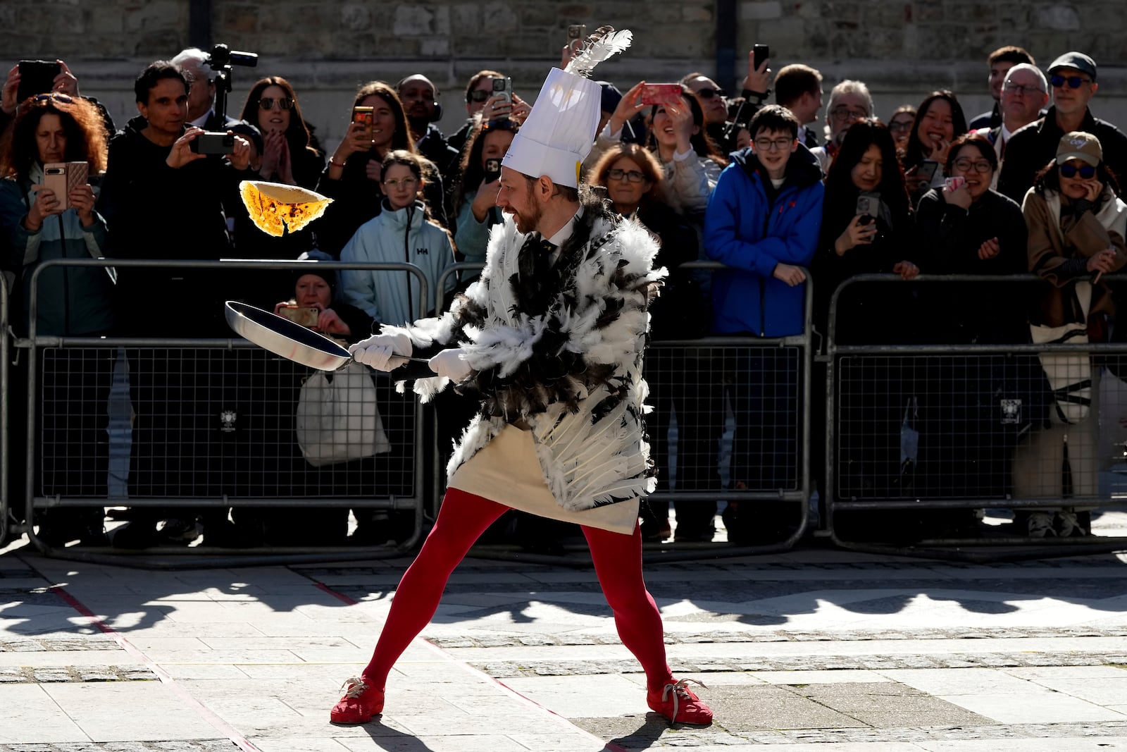 A runner competes during a traditional pancake race by livery companies at the Guildhall in London, Tuesday, March 4, 2025.(AP Photo/Frank Augstein)