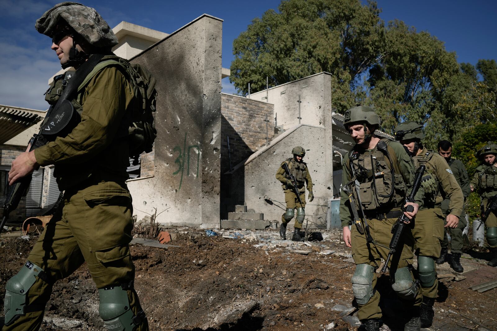 Israeli soldiers inspect the site where a rocket fired from Lebanon landed in a backyard in Kiryat Shmona, northern Israel, Tuesday Nov. 26, 2024. (AP Photo/Leo Correa)