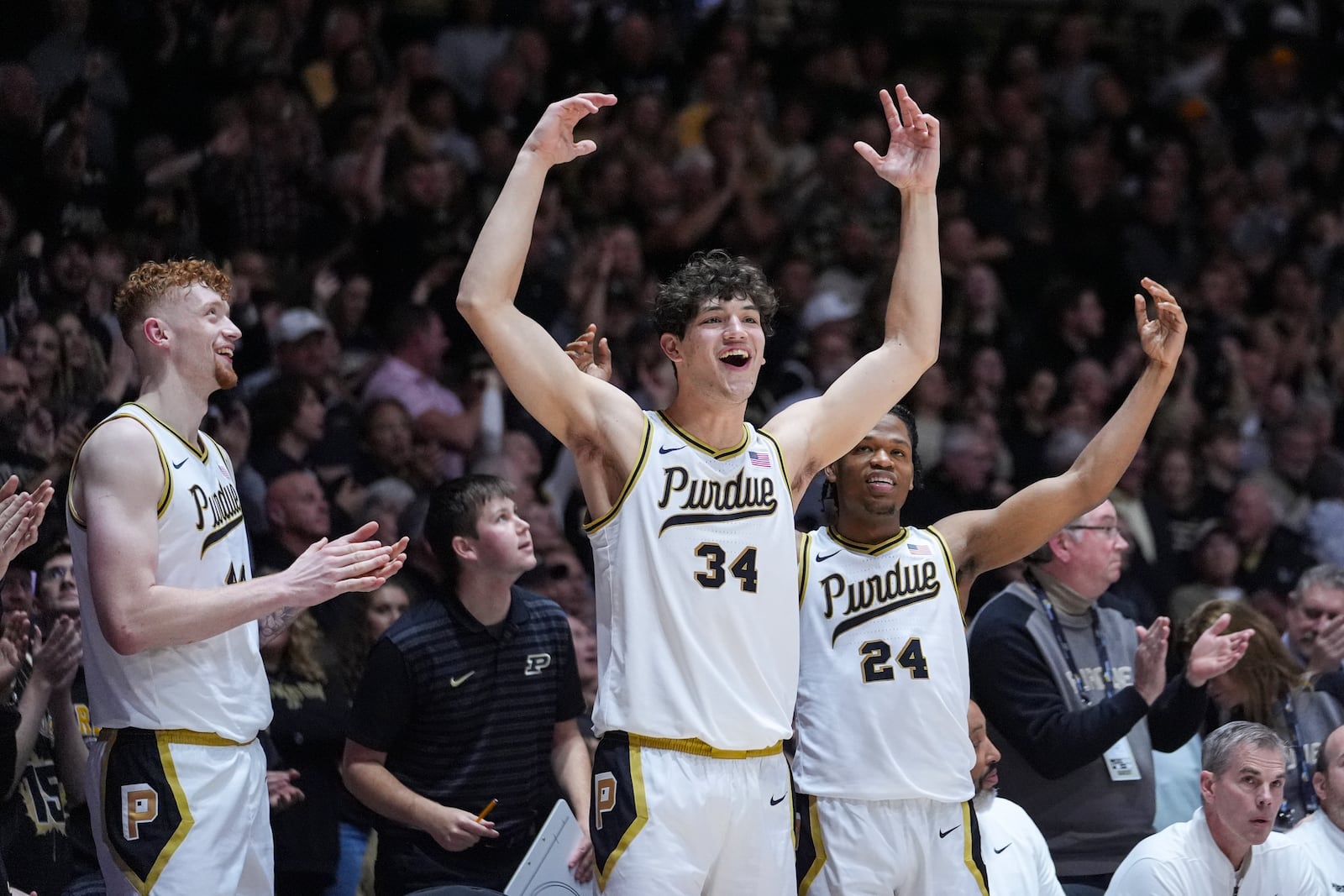 Purdue players, left to right, center Will Berg (44), forward Raleigh Burgess (34) and guard Gicarri Harris (24) celebrates on the bench during the second half of an NCAA college basketball game against Alabama in West Lafayette, Ind., Friday, Nov. 15, 2024. (AP Photo/Michael Conroy)