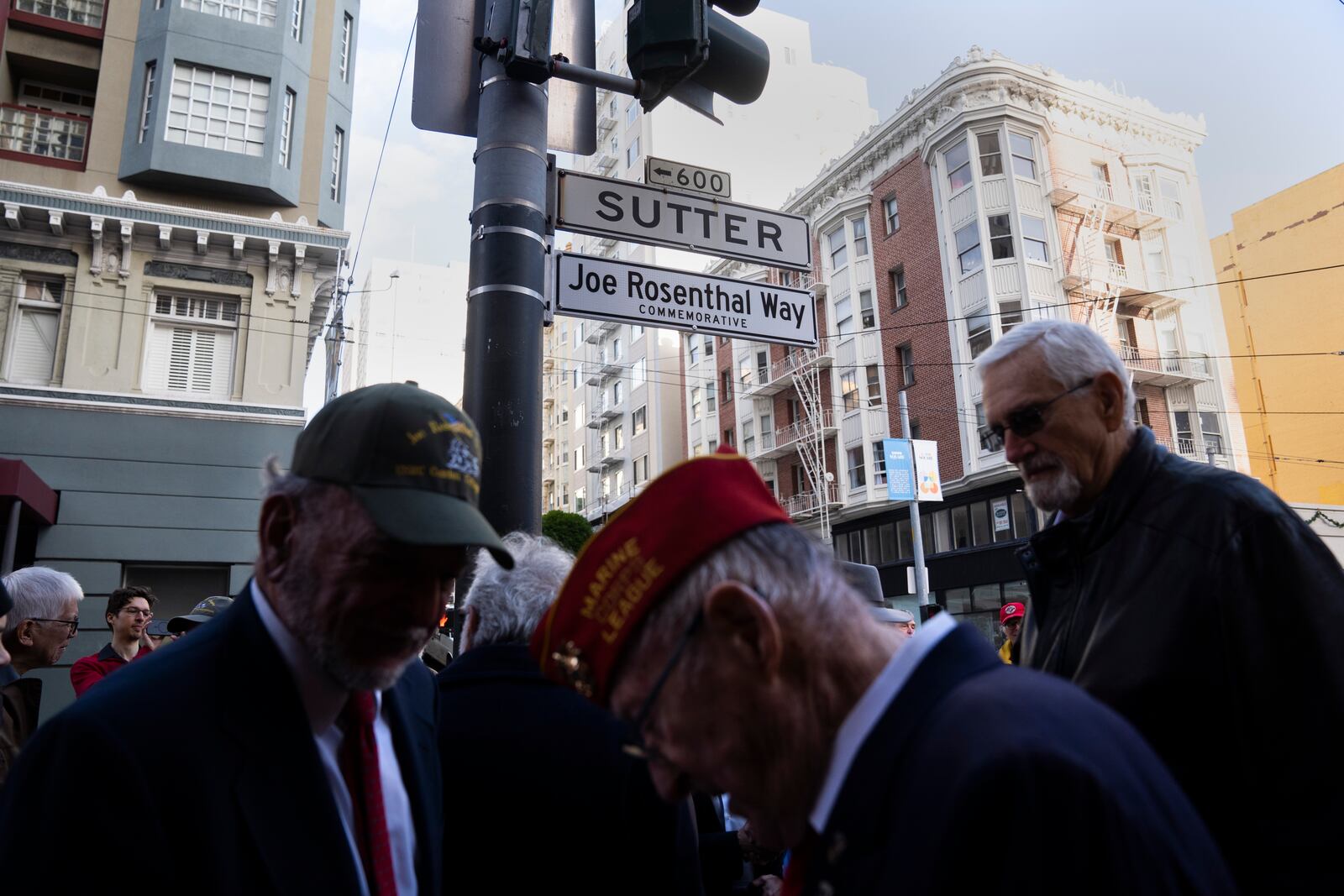 People gather by the street sign Joe Rosenthal Way, that honors the former AP photojournalist who won the Pulitzer Prize for his iconic photo of U.S. Marines raising the flag on the Japanese island of Iwo Jima during WWII, Thursday, Dec. 12, 2024, in San Francisco. (AP Photo/Minh Connors)