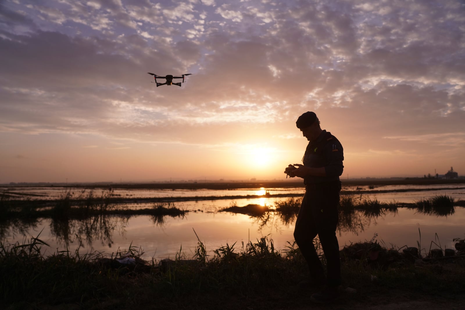 As the search for bodies continues, a Civil Guard flies a drone at the mouth of the Poyo ravine in the La Albufera natural lake near Puerto de Catarroja, Valencia on the outskirts of Valencia, Spain, Tuesday, Nov. 5, 2024. (AP Photo/Alberto Saiz)