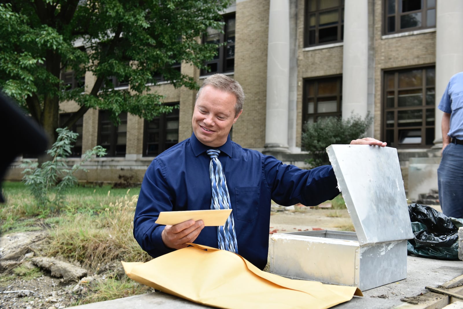 Current Middletown Middle School Principal Michael Valenti empties items out of a time capsule.