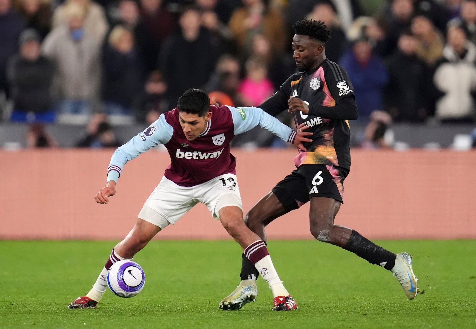 West Ham United's Edson Alvarez, left, and Leicester City's Wilfred Ndidi battle for the ball during the English Premier League soccer match between West Ham United and Leicester City at the London Stadium, London, Thursday Feb. 27, 2025. (John Walton/PA via AP)