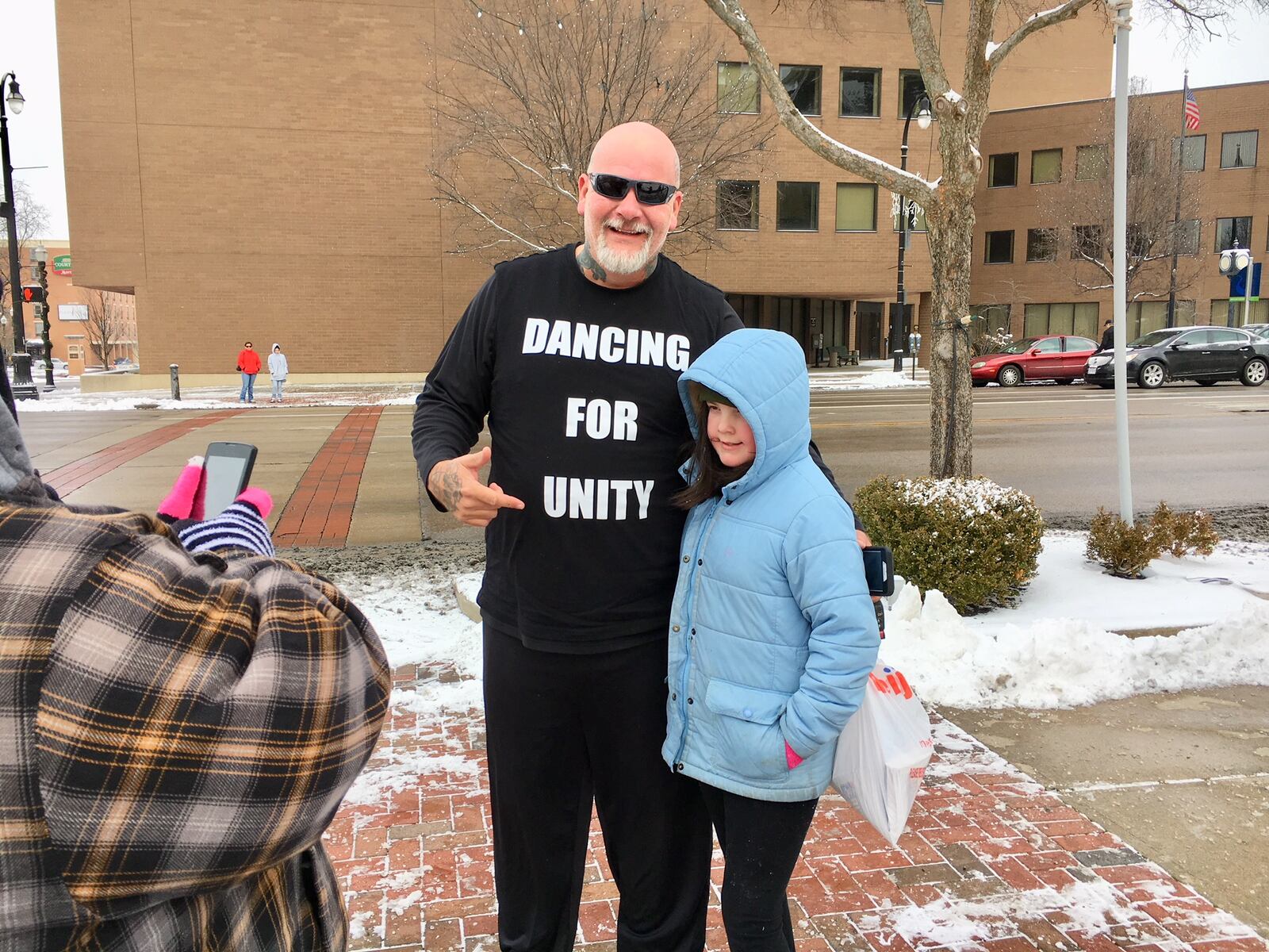 More than 60 area residents braved frigid cold Saturday to join hands in unity formation at the urging of the Hamilton City’s popular “Dancing Trucker.” Among the supporters of John Drury was Hamilton Mayor Pat Moeller.(Photo by Michael D. Clark)