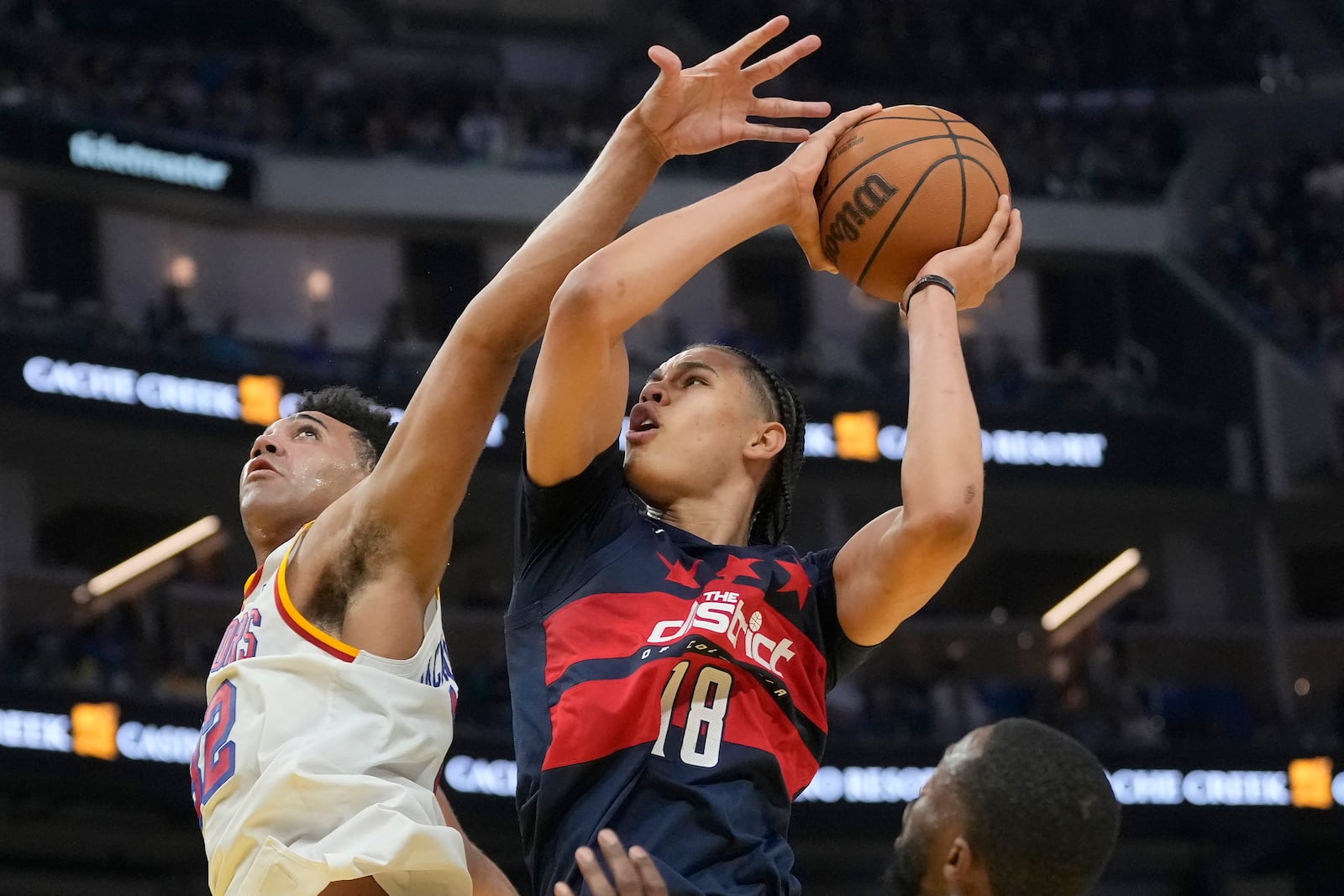 Washington Wizards forward Kyshawn George (18) shoots against Golden State Warriors forward Trayce Jackson-Davis during the first half of an NBA basketball game in San Francisco, Saturday, Jan. 18, 2025. (AP Photo/Jeff Chiu)