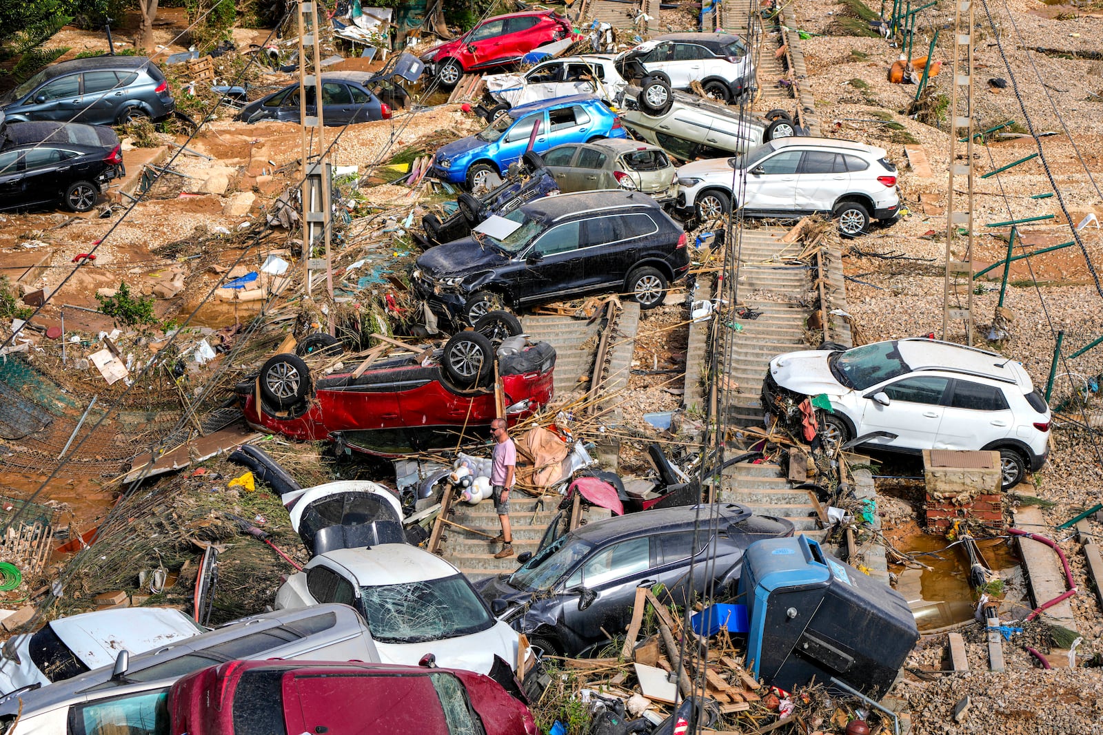 A man stands among flooded cars piled up in Valencia, Spain, Thursday, Oct. 31, 2024. (AP Photo/Manu Fernandez)