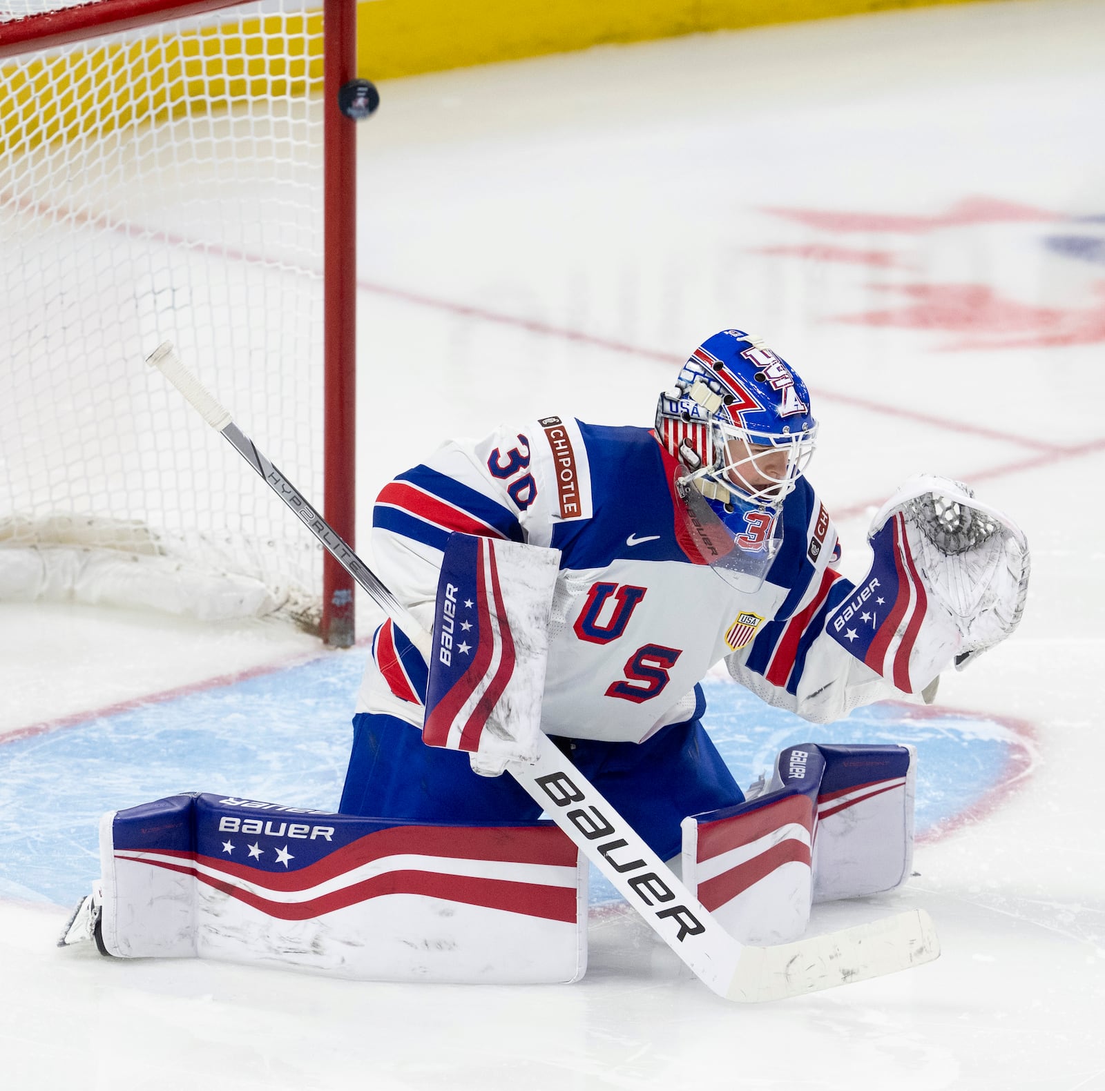 The puck bounces off the post behind United States goaltender Hampton Slukynsky during third-period IIHF World Junior Hockey Championship tournament game action against Latvia, Saturday, Dec. 28, 2024, in Ottawa, Ontario. (Adrian Wyld/The Canadian Press via AP)