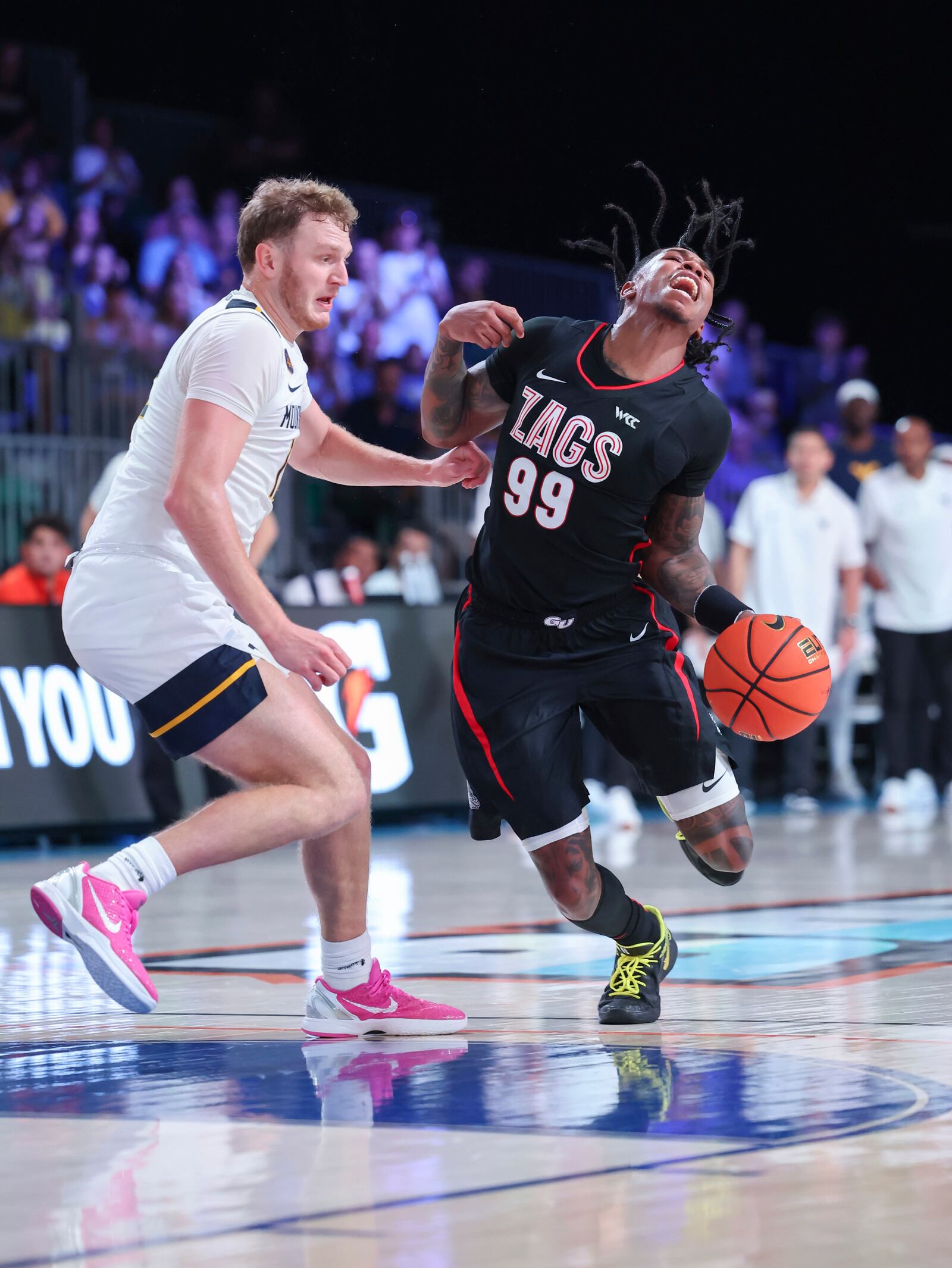 In this handout provided by Bahamas Visual Services, Gonzaga guard Khalif Battle (99) drives against West Virginia guard Tucker DeVries, left, during an NCAA college basketball game at the Battle 4 Atlantis tournament in Paradise Island, Bahamas Wednesday, Nov. 27, 2024. (Tim Aylen/Bahamas Visual Services via AP)