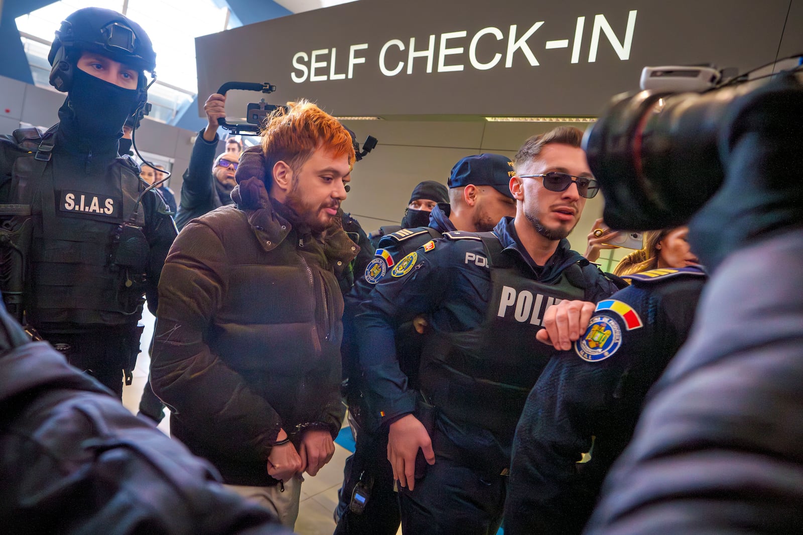 Mohamed Amra, nicknamed ''The Fly", is escorted by armed police officers at the Henri Coanda international airport in Otopeni, Romania, Tuesday, Feb. 25, 2025, before being extradited to France. (AP Photo/Vadim Ghirda)