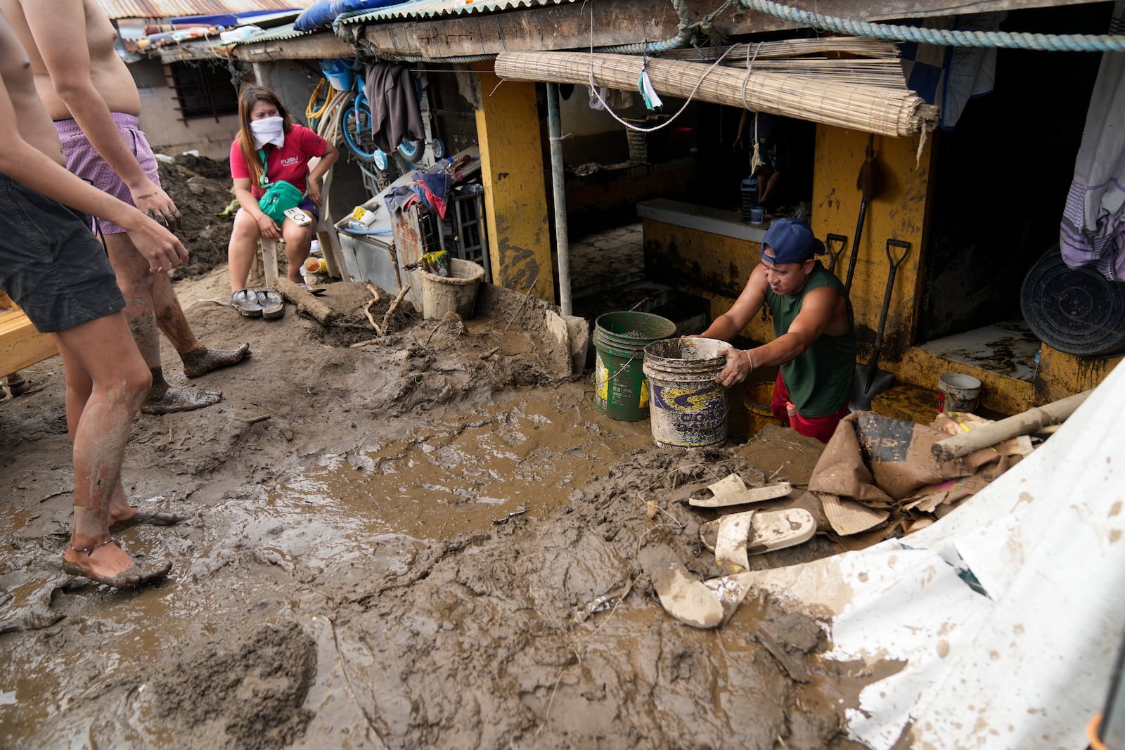 Residents clear out mud from their homes after a landslide triggered by Tropical Storm Trami recently struck Talisay, Batangas province, Philippines, Saturday, Oct. 26, 2024. (AP Photo/Aaron Favila)