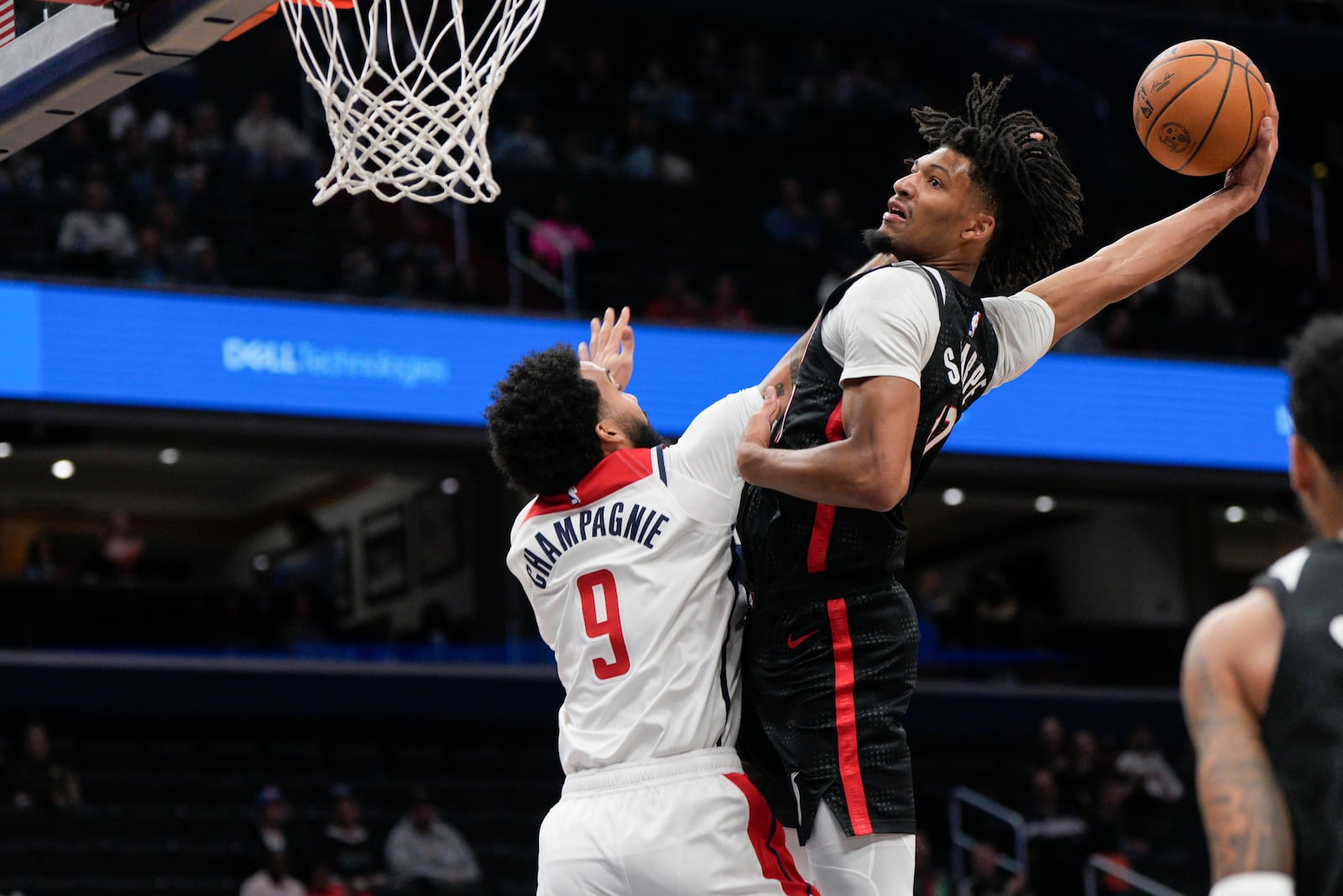 Portland Trail Blazers guard Shaedon Sharpe (17) dunks against Washington Wizards forward Justin Champagnie (9) during the first half of an NBA basketball game, Wednesday, Feb. 26, 2025, in Washington. (AP Photo/Jess Rapfogel)