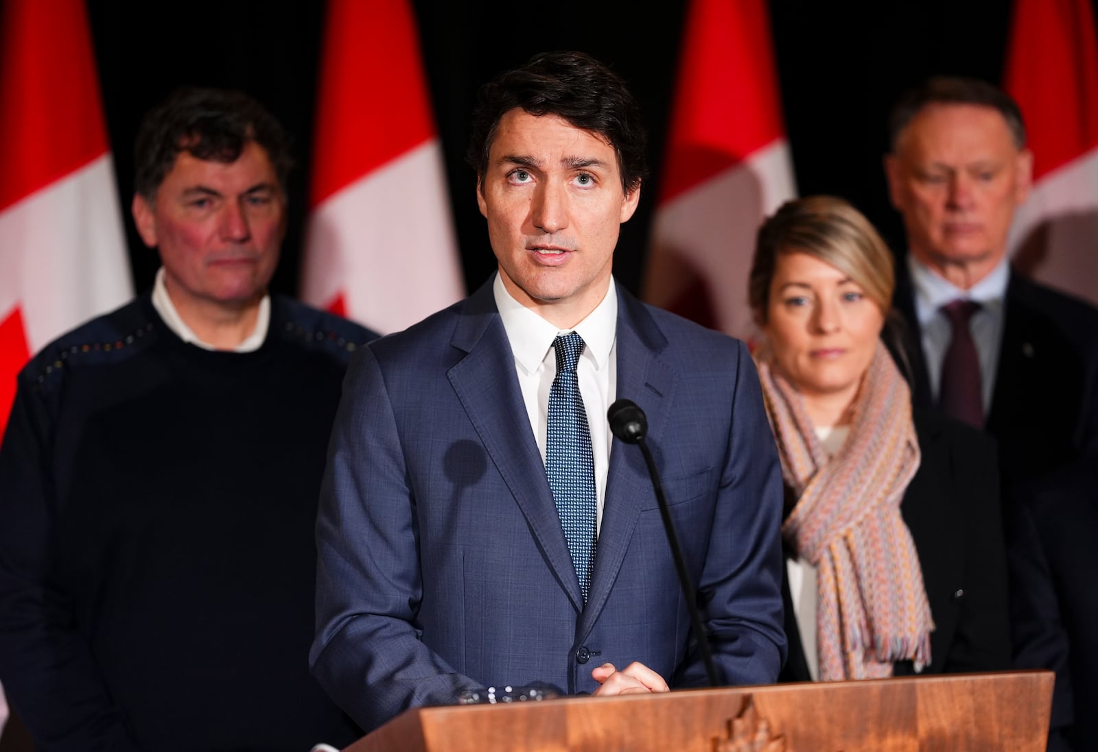 Canadian Prime Minister Justin Trudeau is joined by Minister of Finance Dominic LeBlanc, back left to right, Minister of Foreign Affairs Melanie Joly, Minister of Public Safety David McGuinty, as he holds a press conference during a cabinet retreat at Chateau Montebello in Montebello, Tuesday, Jan. 21, 2025. (Sean Kilpatrick/The Canadian Press via AP)