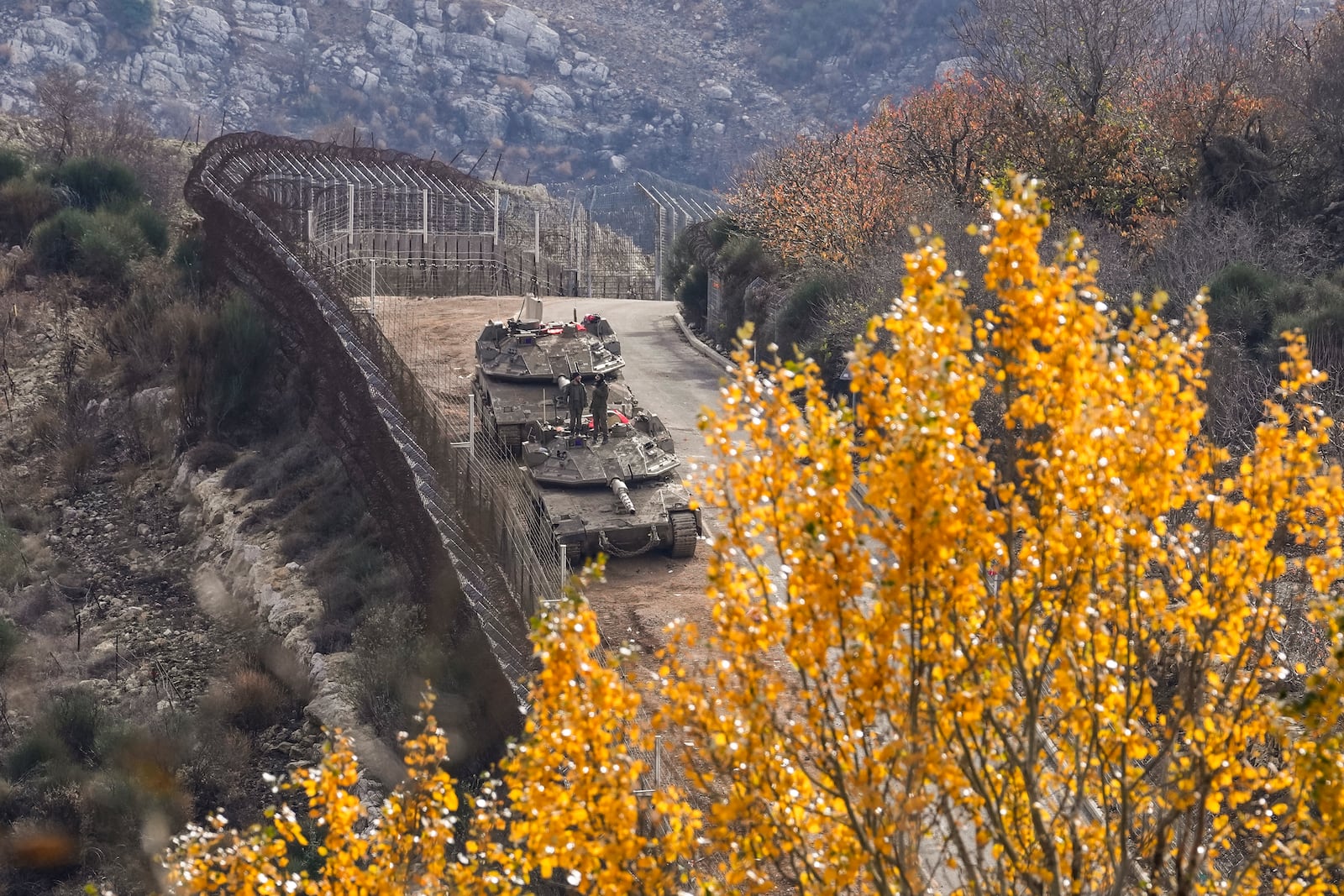 Israeli soldiers stand on the top of a tank near the so-called Alpha Line that separates the Israeli-annexed Golan Heights from Syria, in the town of Majdal Shams, Tuesday, Dec. 10, 2024. (AP Photo/Matias Delacroix)