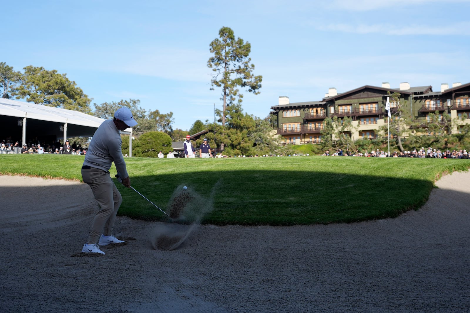 Rory McIlroy, of Northern Ireland, hits out of a bunker on the 18th hole of the South Course at Torrey Pines during the third round of the Genesis Invitational golf tournament Saturday, Feb. 15, 2025, in San Diego. (AP Photo/Gregory Bull)