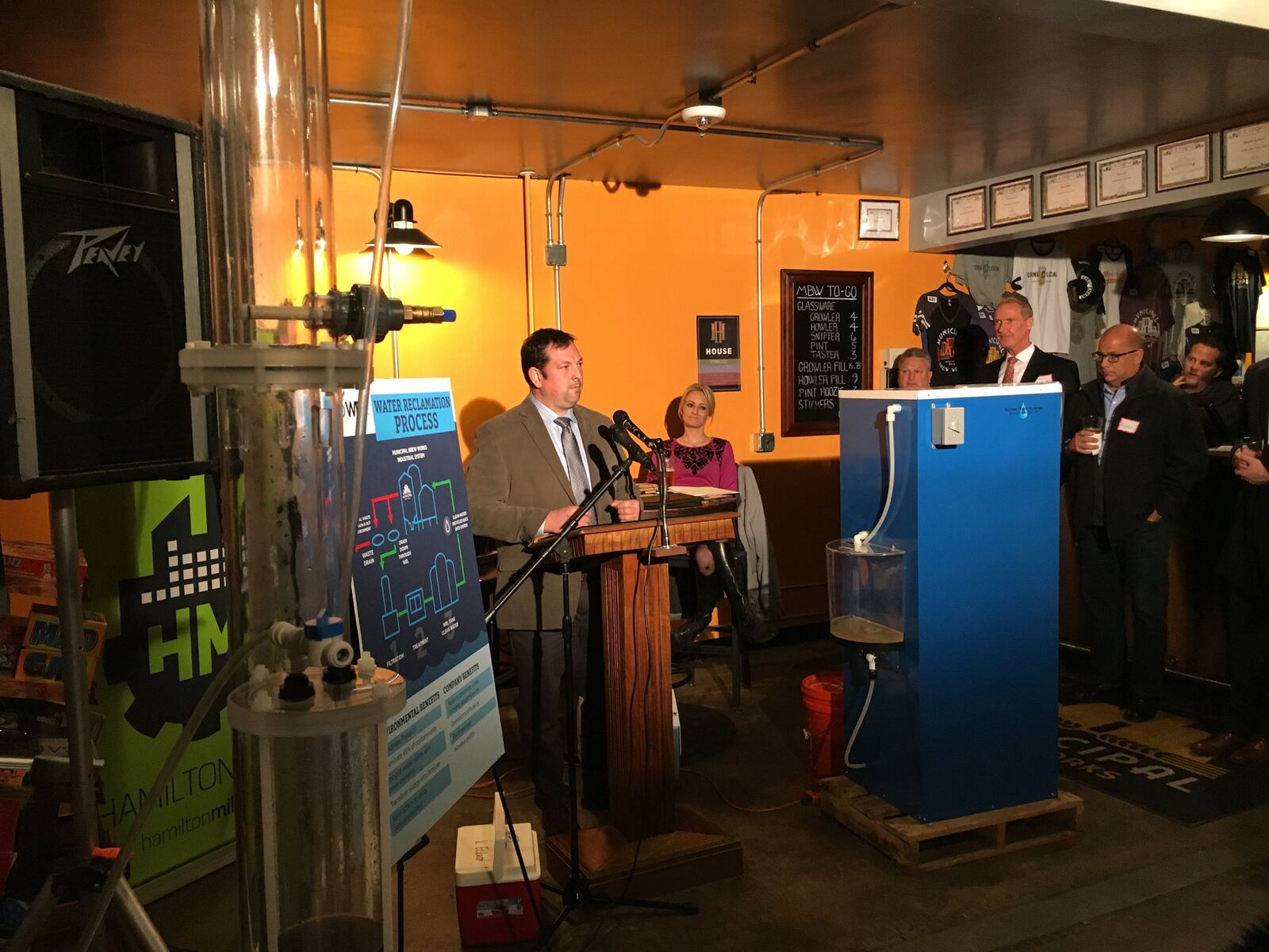 WEL Enterprise CEO Katrina Eckard waited to demonstrate her waste-cleaning machine, at right, while officials spoke about the potential her company and others have to eliminate pollution and waste. MIKE RUTLEDGE/STAFF