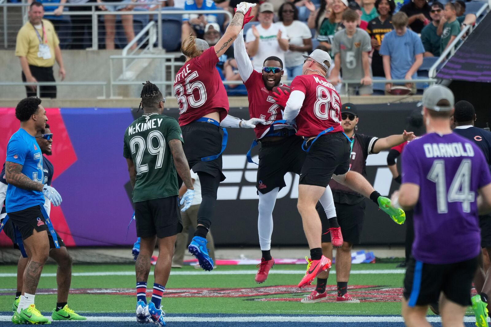 NFC safety Budda Baker (3), of the Arizona Cardinals, celebrates with tight ends George Kittle, of the San Francisco 49ers, and Trey McBride, of the Cardinals, after returning an interception for a touchdown during the flag football event at the NFL Pro Bowl, Sunday, Feb. 2, 2025, in Orlando. (AP Photo/John Raoux)