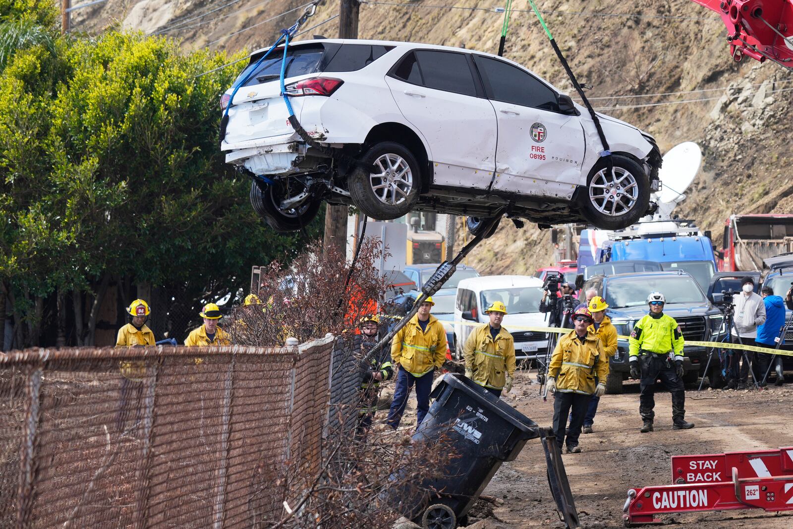 An emergency vehicle is pulled out of the water a day after it was pushed into the surf by debris flow caused by heavy rain, Friday, Feb. 14, 2025, in Malibu, Calif. (AP Photo/Damian Dovarganes)