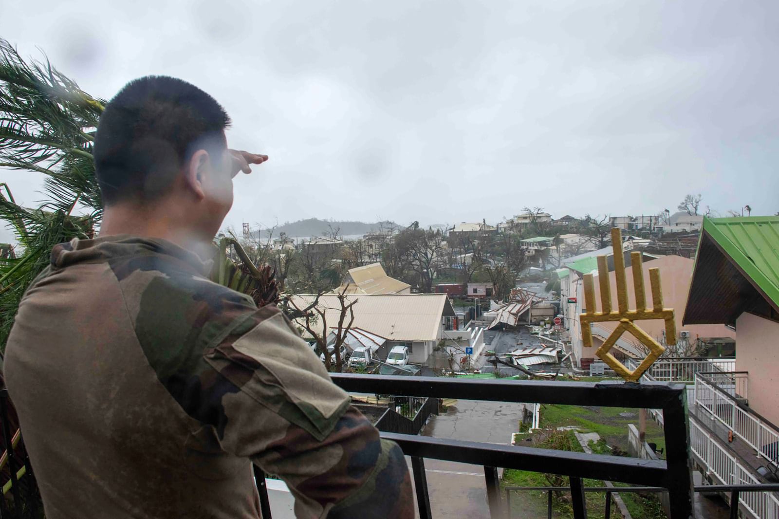 This photo provided Sunday Dec.15, 2024 by the French Army shows a soldier looking at damages in the French territory of Mayotte in the Indian Ocean, after Cyclone Chido caused extensive damage with reports of several fatalities. (Etat Major des Armées via AP)