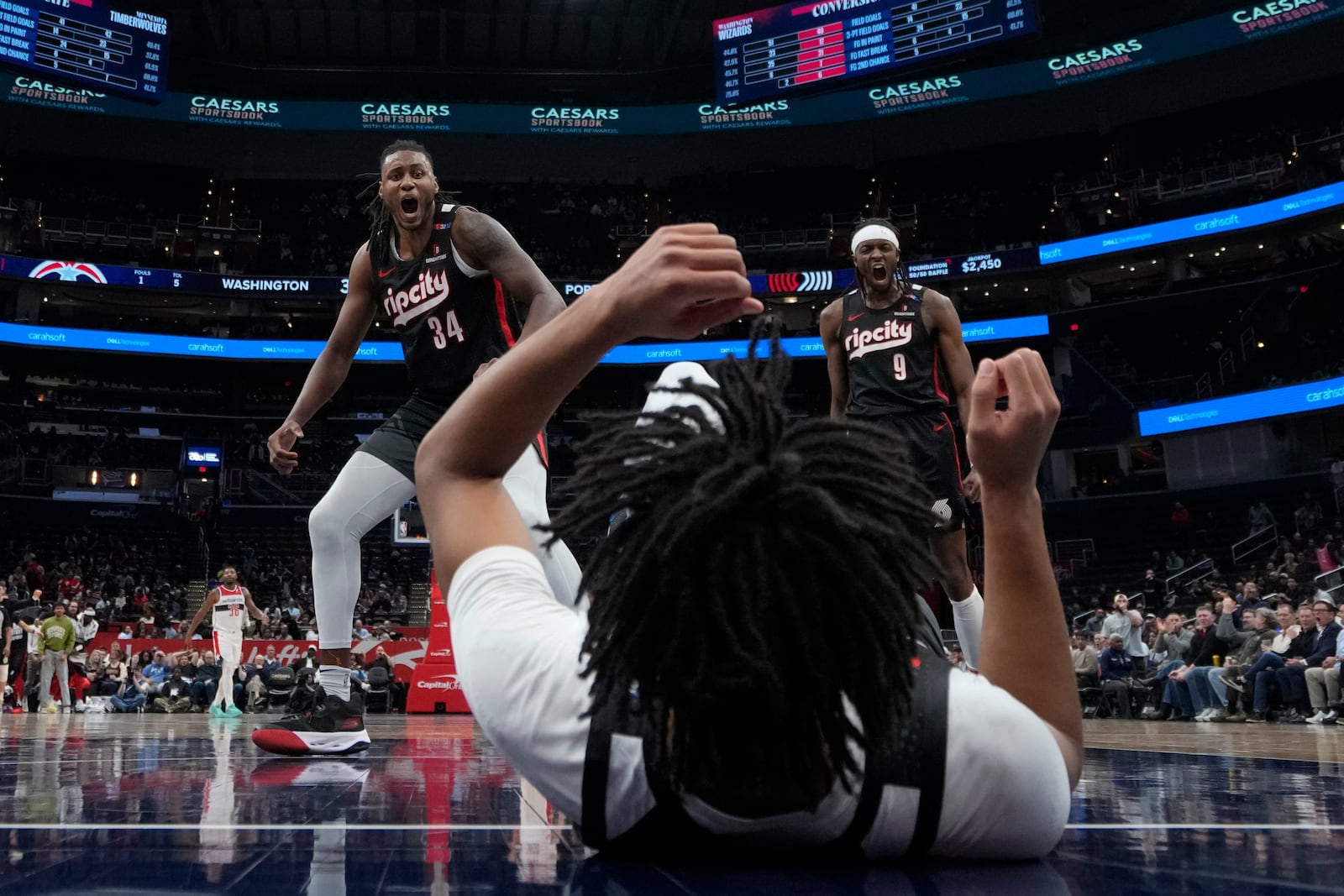 Portland Trail Blazers forwards Jabari Walker (34) and PJerami Grant (9) react after guard Shaedon Sharpe, center, dunks against the Washington Wizards during the second half of an NBA basketball game, Wednesday, Feb. 26, 2025, in Washington. (AP Photo/Jess Rapfogel)