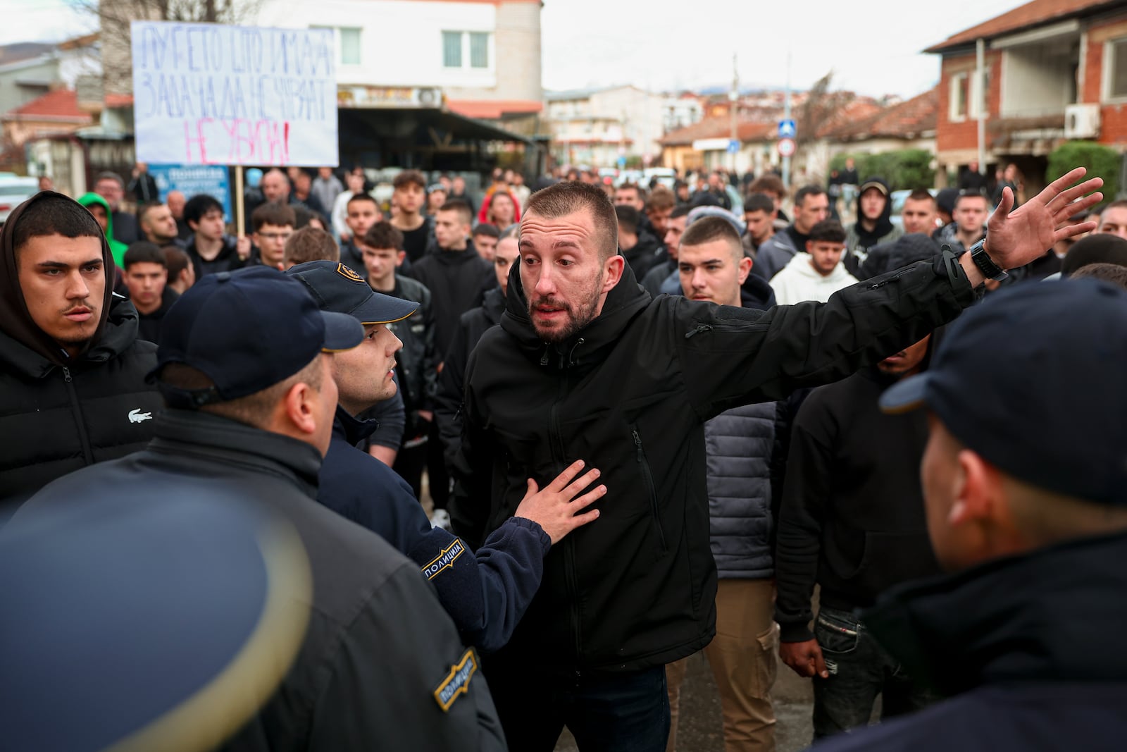 People argue with policemen, outside the home of the owner of a nightclub that was the scene of a massive fire, after a vigil for the victims in the town of Kocani, North Macedonia, Monday, March 17, 2025. (AP Photo/Armin Durgut)