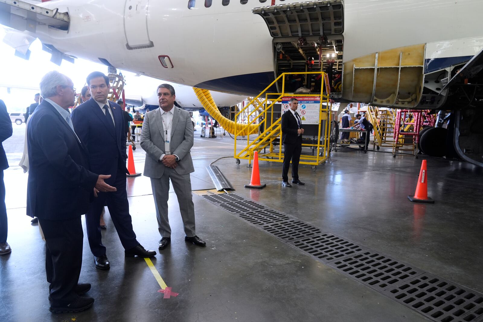 U.S. Secretary of State Marco Rubio talks to Roberto Kriete, left, during a visit to the facilities of aircraft maintenance firm Aeroman in San Luis Talpa, El Salvador, Monday, Feb. 3, 2025. (AP Photo/Mark Schiefelbein, Pool)