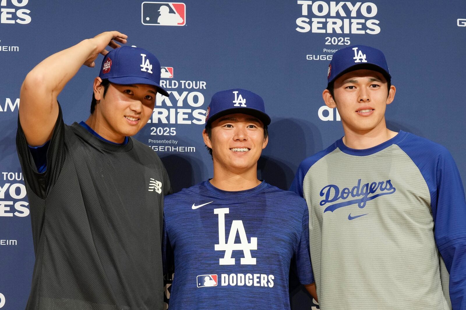 Los Angeles Dodgers Shohei Ohtani, left, Yoshinobu Yamamoto, center, and Roki Sasaki, right, pose for photographs during the official Press conference Friday, March 14, 2025, in Tokyo, as the Dodgers play their MLB opening games against the Chicago Cubs at Tokyo Dome next week. (AP Photo/Eugene Hoshiko)