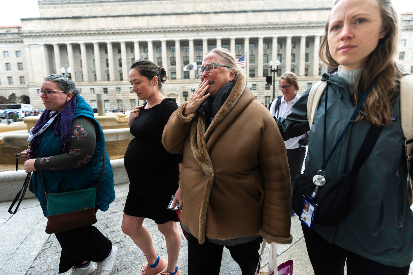 Lucy Mize, second from right, a United States Agency for International Development (USAID) health officer for 31 years, cries as she walks with fellow USAID workers to the USAID headquarters in Washington, to gather personal belongings, Thursday, Feb. 27, 2025, in Washington. (AP Photo/Manuel Balce Ceneta)