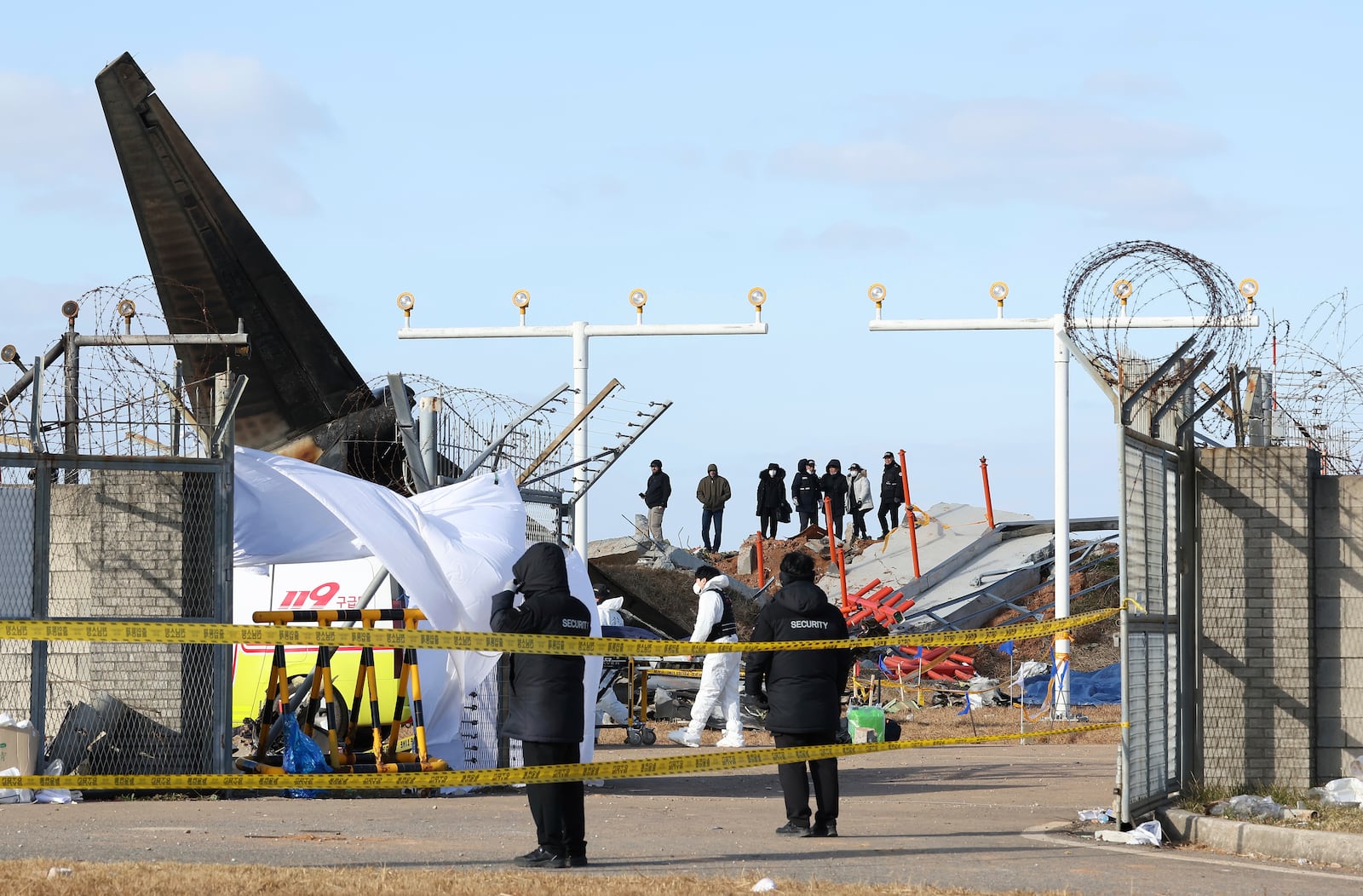 Experts from the U.S. National Transportation Safety Board (NTSB) and representatives from aircraft manufacturer Boeing Co. investigate the site of a plane crash at Muan International Airport in Muan, South Korea, Tuesday, Dec. 31, 2024. (Kim Sung-min/Yonhap via AP)