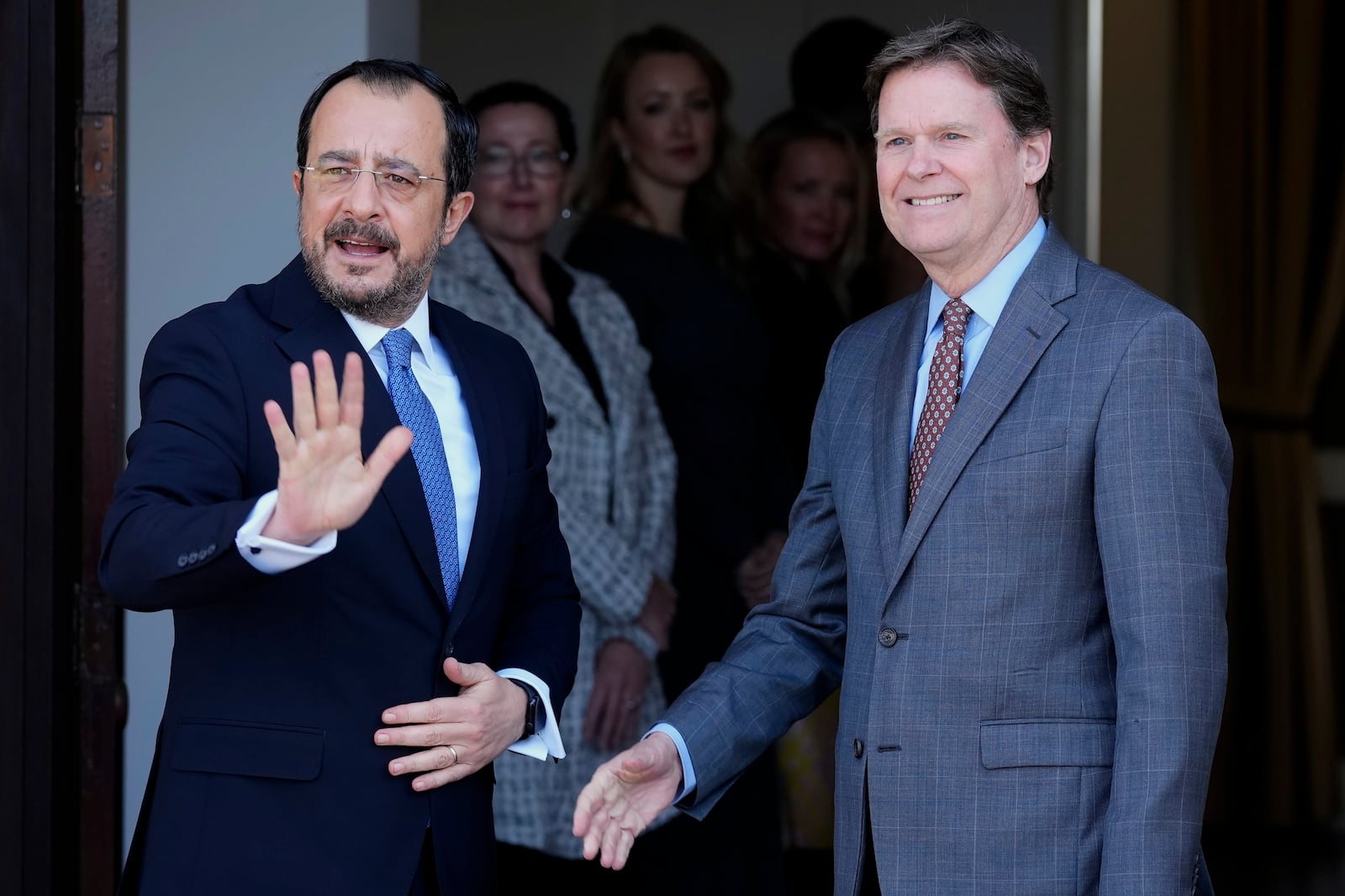 United Nations Chief of Mission in Cyprus Colin Stewart, right, smiles as Cypriot President Nikos Christodoulides waves to the media when he arrived for a meeting with the leader of the breakaway Turkish Cypriots Ersin Tatar at the U.N. official's residence inside a U.N.-controlled buffer zone cutting across the divided capital Nicosia, Cyprus, Monday, Jan. 20, 2025. (AP Photo/Petros Karadjias)