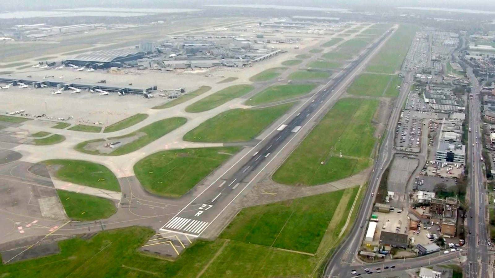 This image taken from video shows a deserted runaway with parked planes on the background at Heathrow airport, as a fire at the North Hyde electrical substation on Thursday night has led to a closure of Heathrow Airport in London, Friday, March 21, 2025. (Sky News via AP)